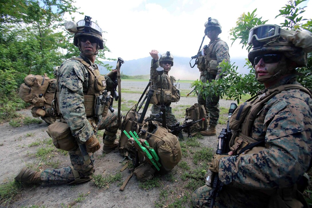 Marines with the headquarters element of Golf Company, Battalion Landing Team 2nd Battalion, 1st Marines Regiment, 11th Marine Expeditionary Unit, call over a Marine for communication set up during a long-range raid at Marine Corps Training Area Bellows, Hawaii, as part of their Western Pacific 14-2 deployment Aug. 1, 2014.The 11th MEU and Makin Island Amphibious Ready Group are deploying as a sea-based, expeditionary crisis response force capable of conducting amphibious missions across the full range of military operations. (U.S. Marine Corps photo by Cpl. Demetrius Morgan/ RELEASED) 