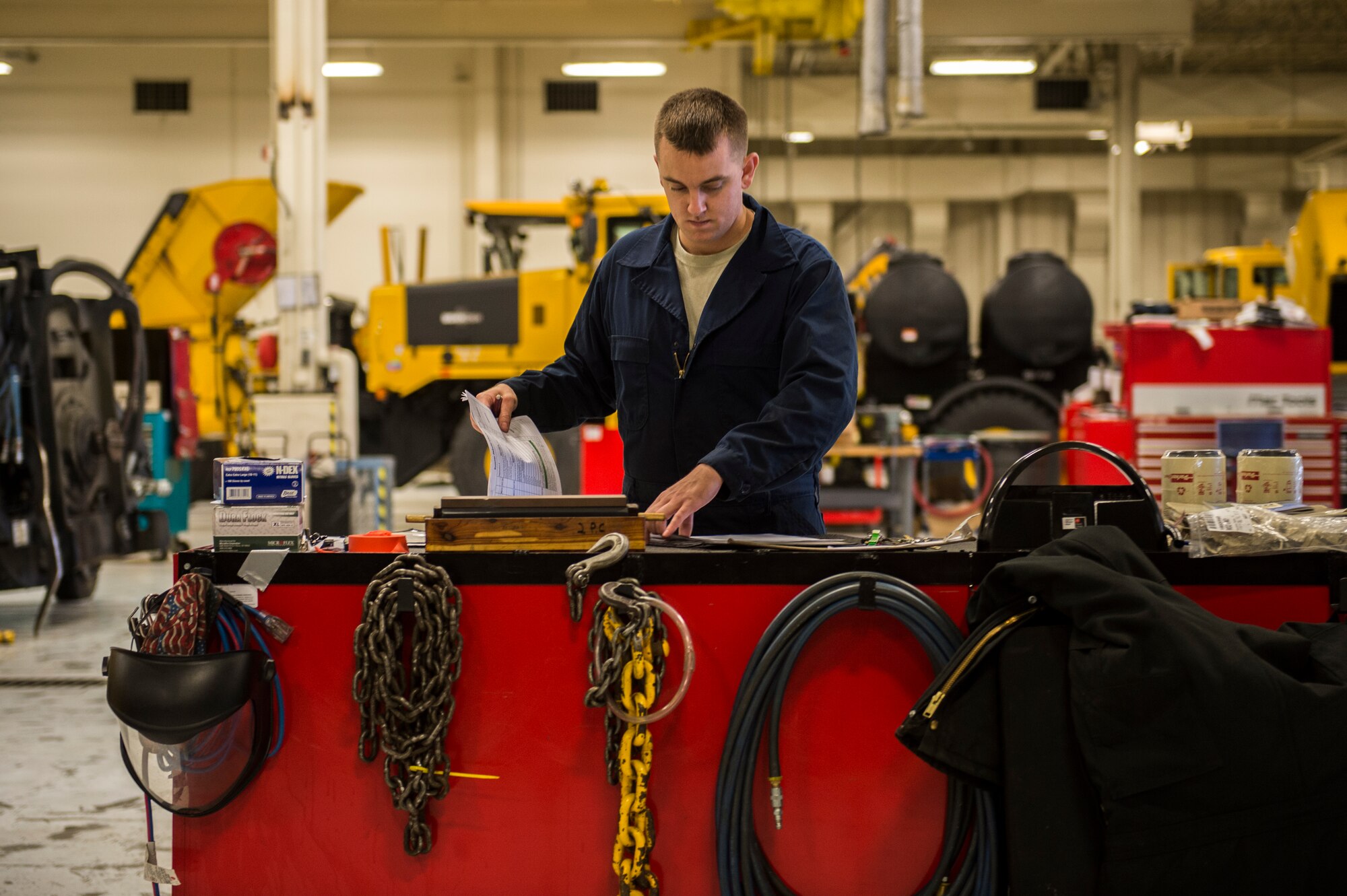 Senior Airman Anthony Tavares, 354th Logistics Readiness Squadron vehicle maintainer, checks paperwork before inspecting and maintaining a flightline snow broom at Eielson Air Force Base, Alaska, Aug. 4, 2014. The 354th LRS is responsible for managing and maintaining the government vehicle fleet which incorporates an immense and diverse snow fleet in addition to all the cargo, passenger and household goods movements for Eielson AFB. (U.S. Air Force photo by Staff Sgt. Stephany Richards/ Released)