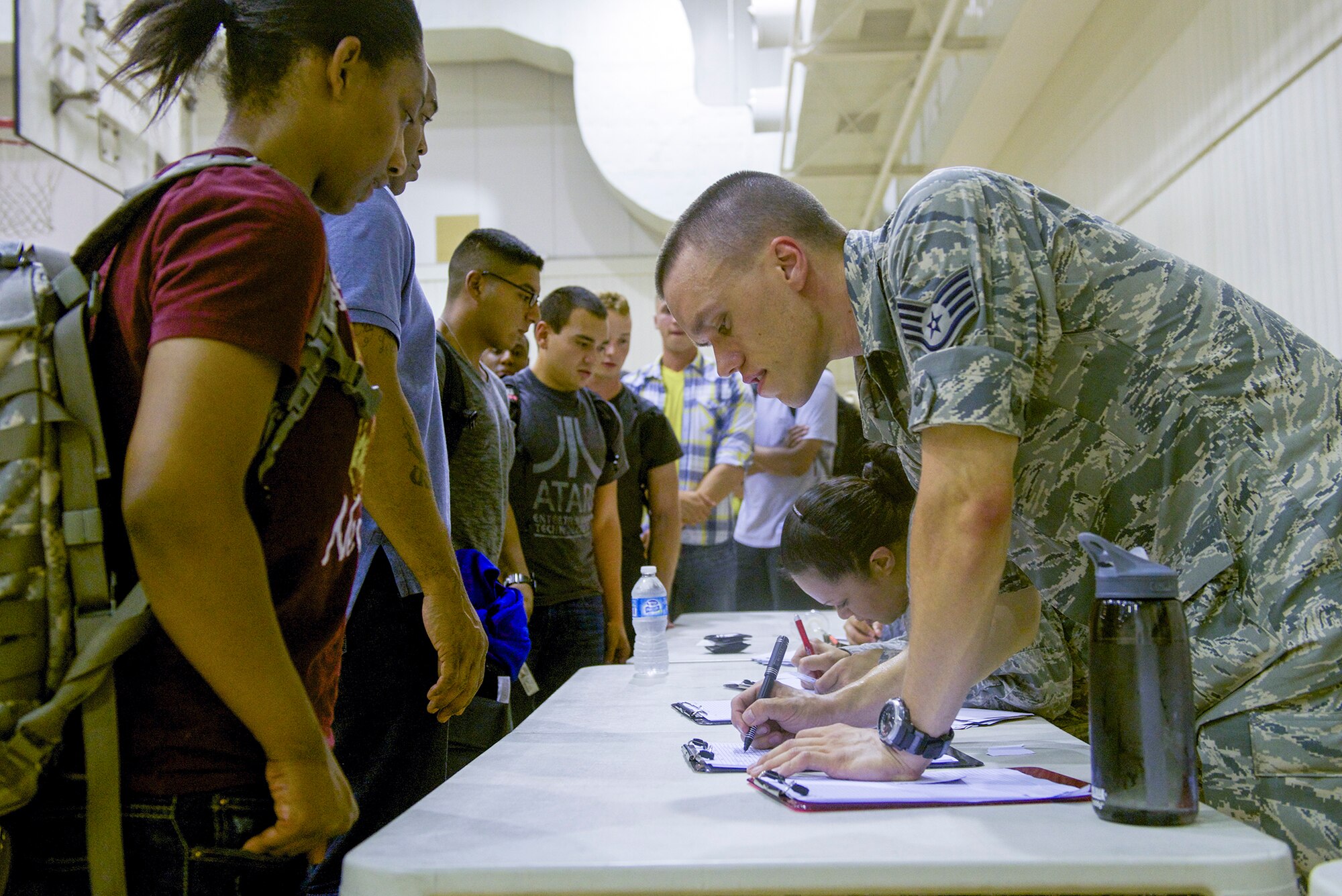 Staff Sgt. Joseph Wolkiewicz, 374th Force Support Squadron special events coordinator, registers personnel staying overnight in the Samurai Fitness Center at Yokota Air Base, Japan, Aug. 1, 2014. Members of the 374 FSS worked together with Airmen of the 374th Civil Engineer Squadron to provide lodging for displaced passengers. (U.S. Air Force photo by Airman 1st Class David C. Danford/Released)
