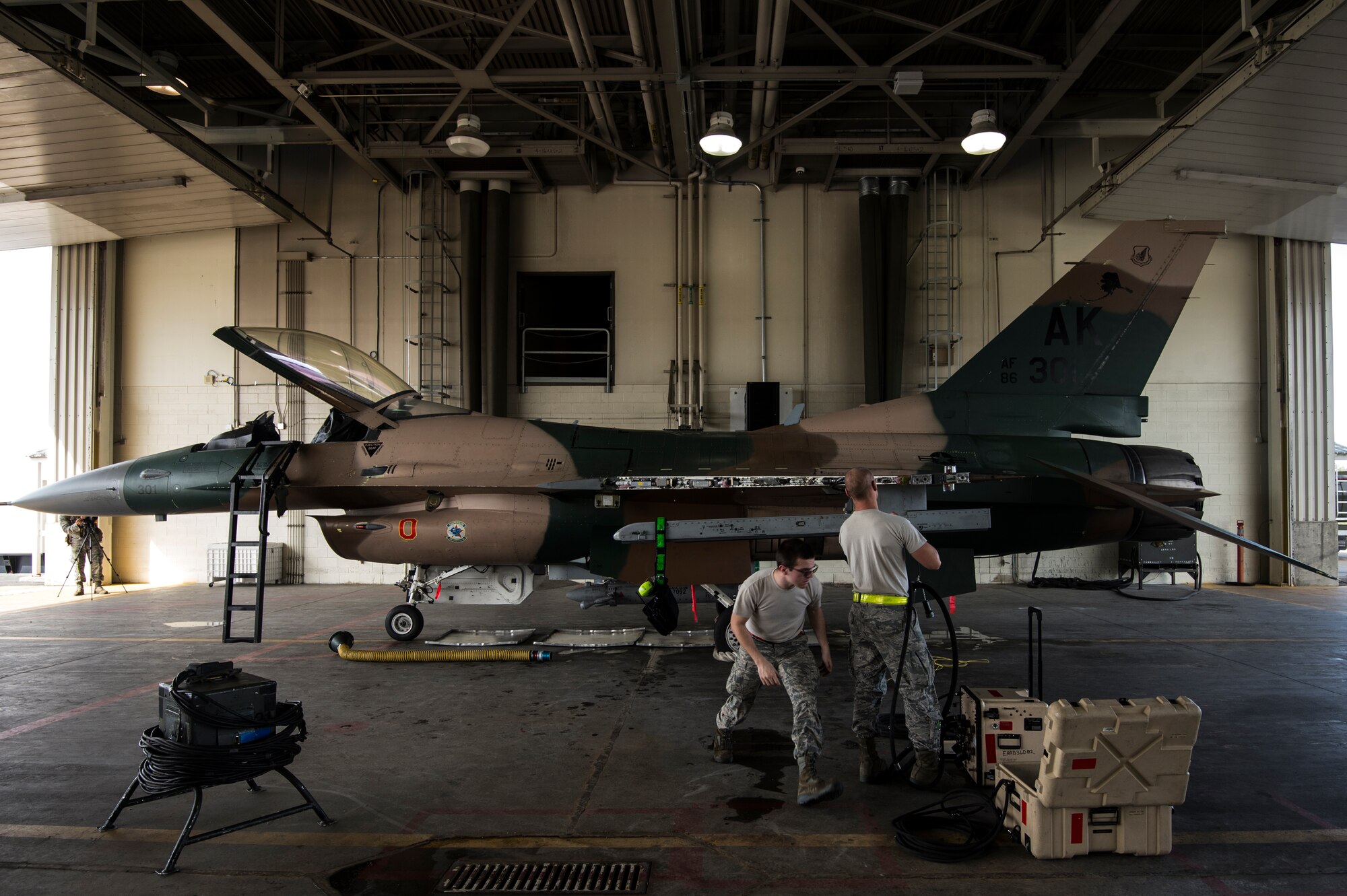 Staff Sgt. Jacob Lee and Airman 1st Class Lawrence Croby, 354th Aircraft Maintenance Squadron weapons load crew, repair the weapons systems on an F-16C Fighting Falcon at Eielson Air Force Base, Alaska, Aug. 4, 2014. The 354th AMS provides mission ready mission ready aircraft to support the wing's F-16 aggressor mission that includes home station, the exercise RED FLAG-Alaska and Aggressor road shows. (U.S. Air Force photo by Staff Sgt. Stephany Richards/ Released)