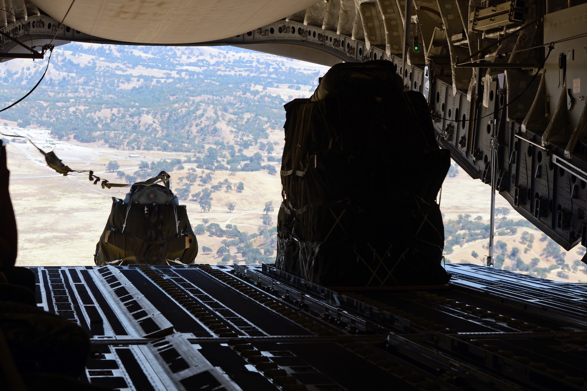 Pilots from the 446th Airlift Wing airdrop two container delivery system bundles from a C-17 Globemaster III aircraft during joint Operation Desert Cougar Aug. 4, 2014, near Schoonover, Calif. The two CDS bundles were part of a scalable force package deployed in the exercise. (U.S. Air Force photo/Airman 1st Class Jacob Jimenez)