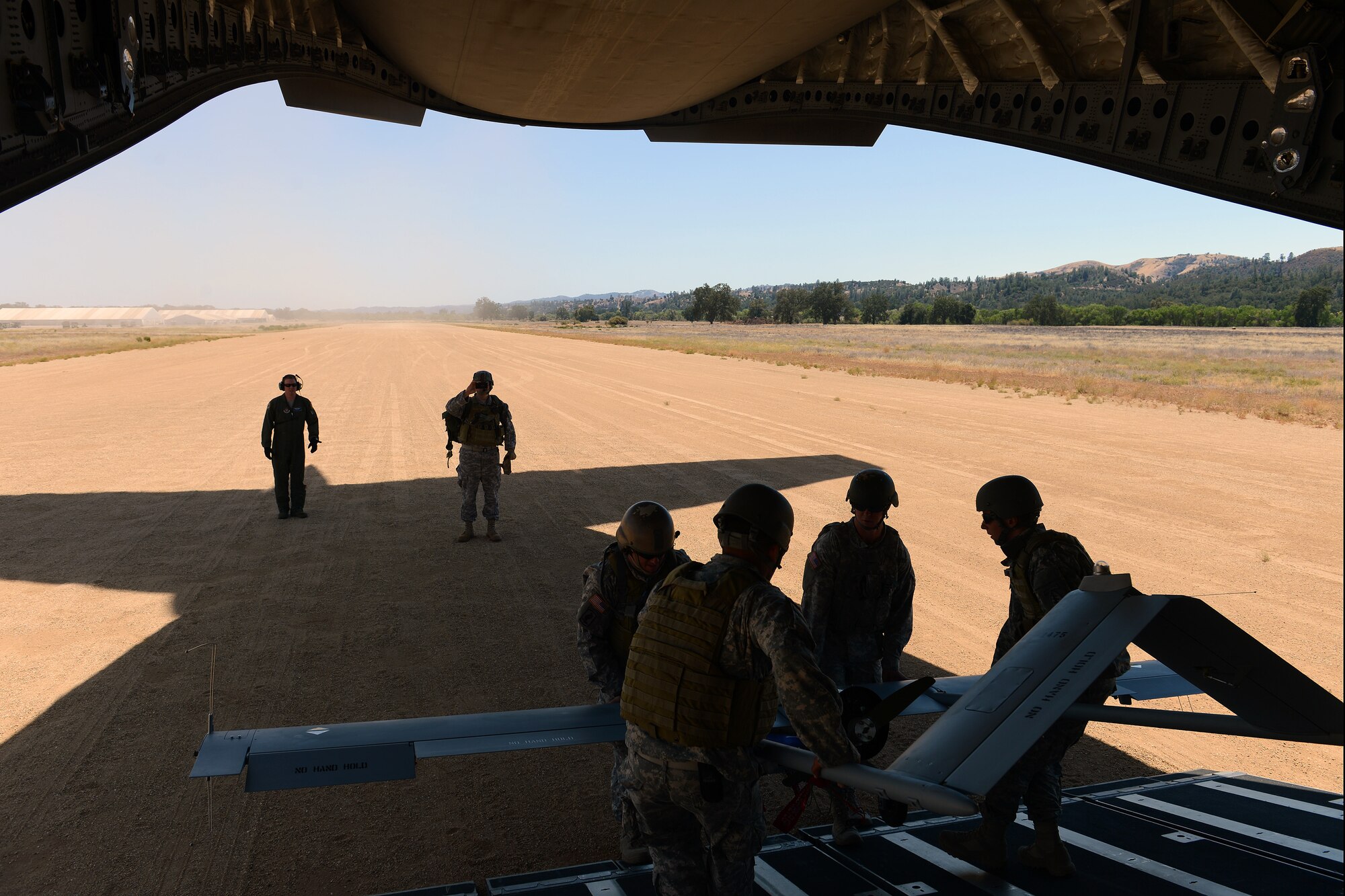 Soldiers from the 1st Special Forces Group (Airborne) unload an unmanned aircraft from a C-17 Globemaster III during joint Operation Desert Cougar Aug. 4, 2014, at Schoonover, Calif. During the exercise Airmen from the 446th Airlift Wing and the 22nd Special Tactics Squadron worked with Soldiers from the 1st SFG to deploy a scalable force package to a simulated area of responsibility. (U.S. Air Force photo/Airman 1st Class Jacob Jimenez) 