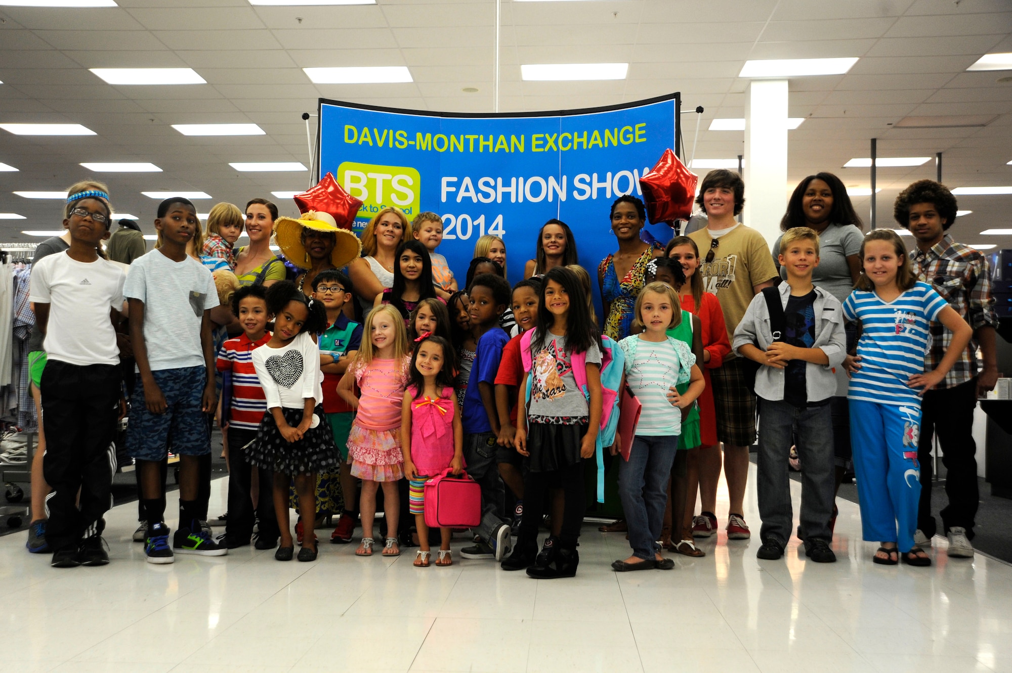 Models pose for a group photo after showcasing clothing sold in the Base Exchange during a Back-to-School Fashion Show held by the Enlisted Spouses Association and the BX, at Davis-Monthan Air Force Base, Ariz., Aug. 2, 2014. To make sure they had something for everyone, they opened up the modeling for kids as young as three to full-time moms who are students themselves. (U.S. Air Force photo by Airman 1st Class Betty R. Chevalier/Released)