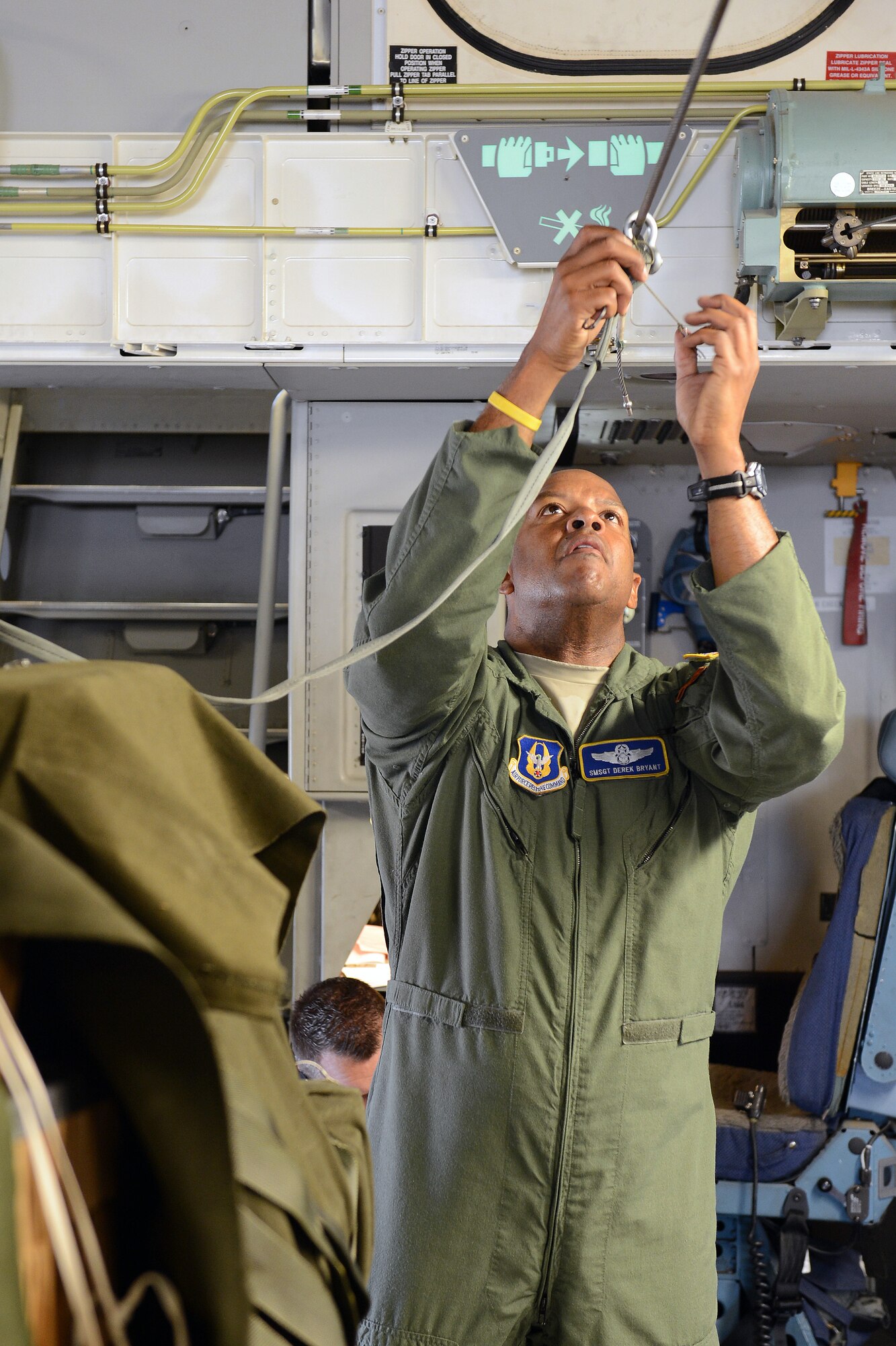 Senior Master Sgt. Derek Bryant, 728th Airlift Squadron loadmaster and chief of standards and evaluations, attaches a static-line to a container delivery system bundle Aug. 4, 2014, at Joint Base Lewis-McChord, Wash. The CDS bundle containing an all-terrain vehicle was airdropped later that day as part of the joint Operation Desert Cougar exercise. (U.S. Air Force photo/Airman 1st Class Jacob Jimenez)