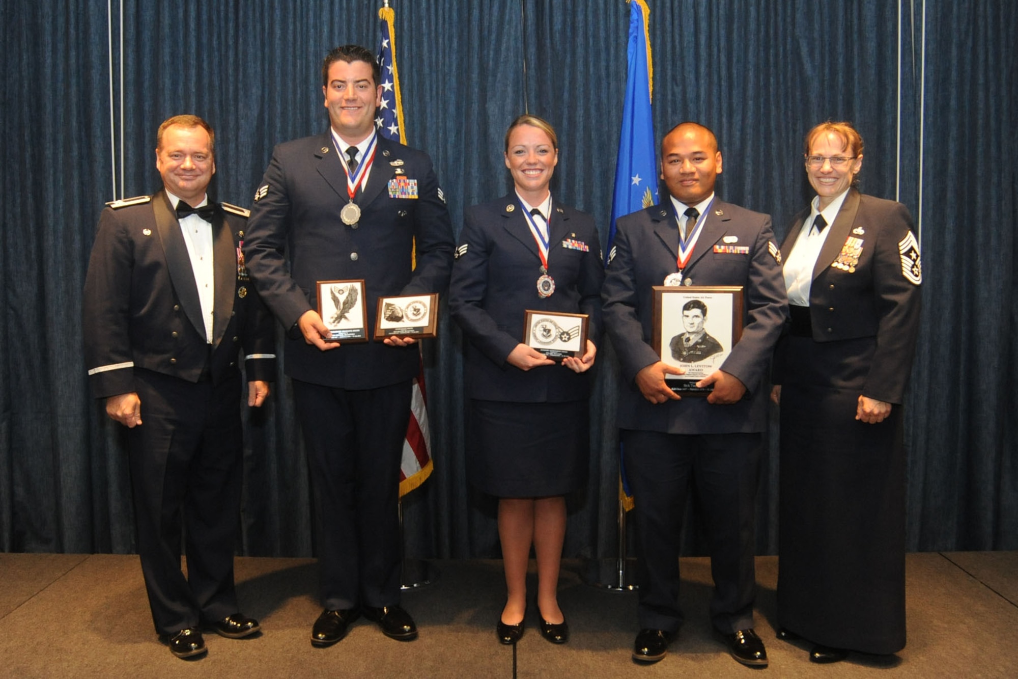 Col. Brian McDaniel and Chief Master Sgt. Wendy Hansen pose for a photo with the award winners at the Airman Leadership School Class 14-F graduation at Fairchild Air Force Base, Washington, July 31, 2014. McDaniel is the 92nd Air Refueling Wing commander and Hansen is the 92nd ARW command chief. ALS is the primary training method of certifying Airmen to be supervisors in their respective career fields. (U.S. Air Force photo by Airman 1st Class Sam Fogleman/Released)