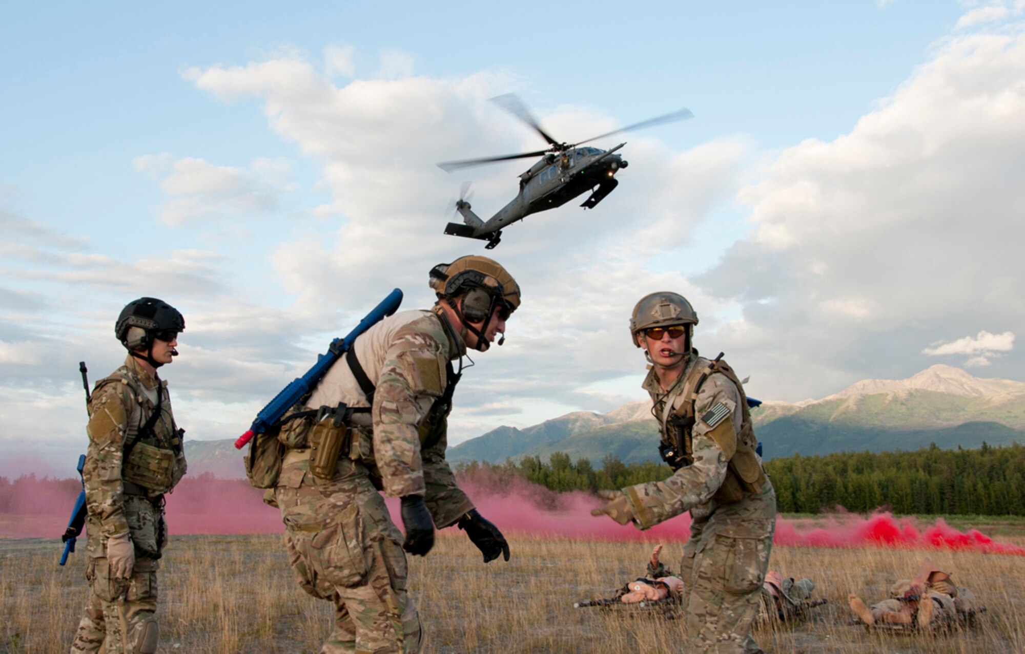 Pararescuemen from the 212th Rescue Squadron, make a plan to evacuate victims as an HH-60 Pave Hawk lands nearby during a routine training mission on Joint Base Elmendorf-Richardson, Alaska, July 30, 2014. The Rescue Squadron trains their team for any military and civilian missions where they may be tasked to recover, rescue or execute a medical evacuation. (U.S. Air Force photo/Airman 1st Class Tammie Ramsouer)