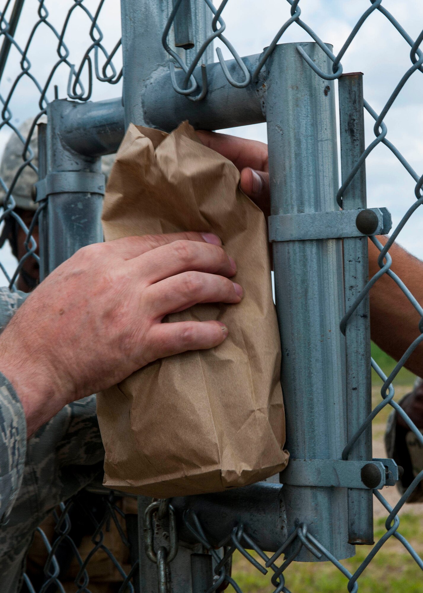 Food is passed through the gate at a launch facility during a morale visit to the missile complex in North Dakota, July 30, 2014. During their regular operations, 791st Airmen patrol the missile complex, and guard teams who are performing regular maintenance to the different sights and assets for upkeep. (U.S. Air Force photo/Senior Airman Stephanie Morris)