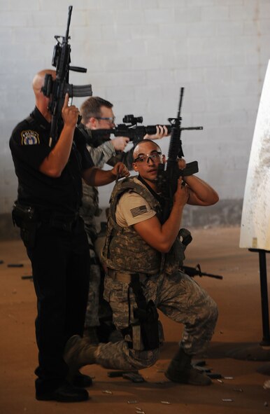Staff Sgt. Nicholas Gallo, 71st Security Forces Squadron combat arms training maintenance (CATM) noncommissioned officer in charge, and Flight Sgt. Joshua Wiederkehr, prepare to run for cover during the Shoot, Move, Communicate training July 28 at the CATM range.  Shoot, Move, Communicate is a mandated annual training designed for security forces Airmen to familiarize them on how to move from cover to cover in stressful situations while directing fire.  (U.S. Air Force photo/Staff Sgt. Nancy Falcon)