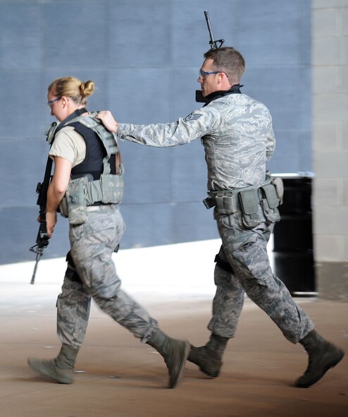 Airman Breanna Kennan, 71st Security Forces Squadron patrolman, moves closely with wingman, Staff Sgt. Jeff Hollis, flight chief, during the Shoot, Move, Communicate training July 28 at the CATM range.  Shoot, Move, Communicate is a mandated annual training designed for security forces Airmen to familiarize them on how to move from cover to cover in stressful situations while directing fire.  (U.S. Air Force photo/Staff Sgt. Nancy Falcon)