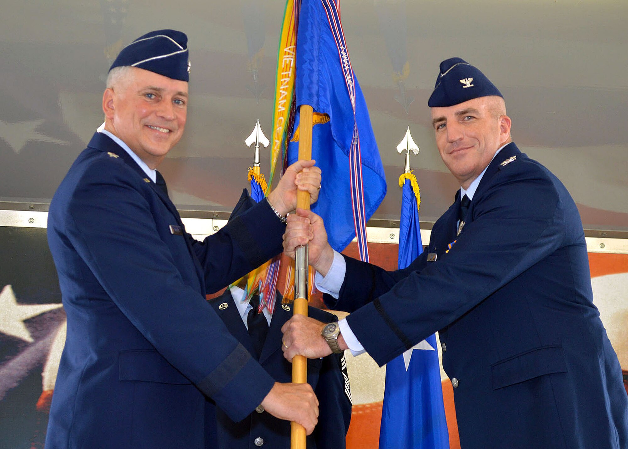 Maj. Gen. Frederick H. Martin, U.S. Air Force Expeditionary Center commander, presents the 43rd Airlift Group’s guidon to Col. Kenneth E. Moss signifying a transfer of command of the group to Moss from the outgoing commander, Col. Daniel H. Tulley, during a change of command ceremony here August 5, 2014. Prior to his current assignment, Moss was a fellow at the U.S. Navy Strategic Studies Group, in Newport, R.I. Tulley, moves on to his next assignment as the commander for the 6th Air Mobility Wing, MacDill Air Force Base, Fla. (U.S. Air Force photo/Marvin Krause)