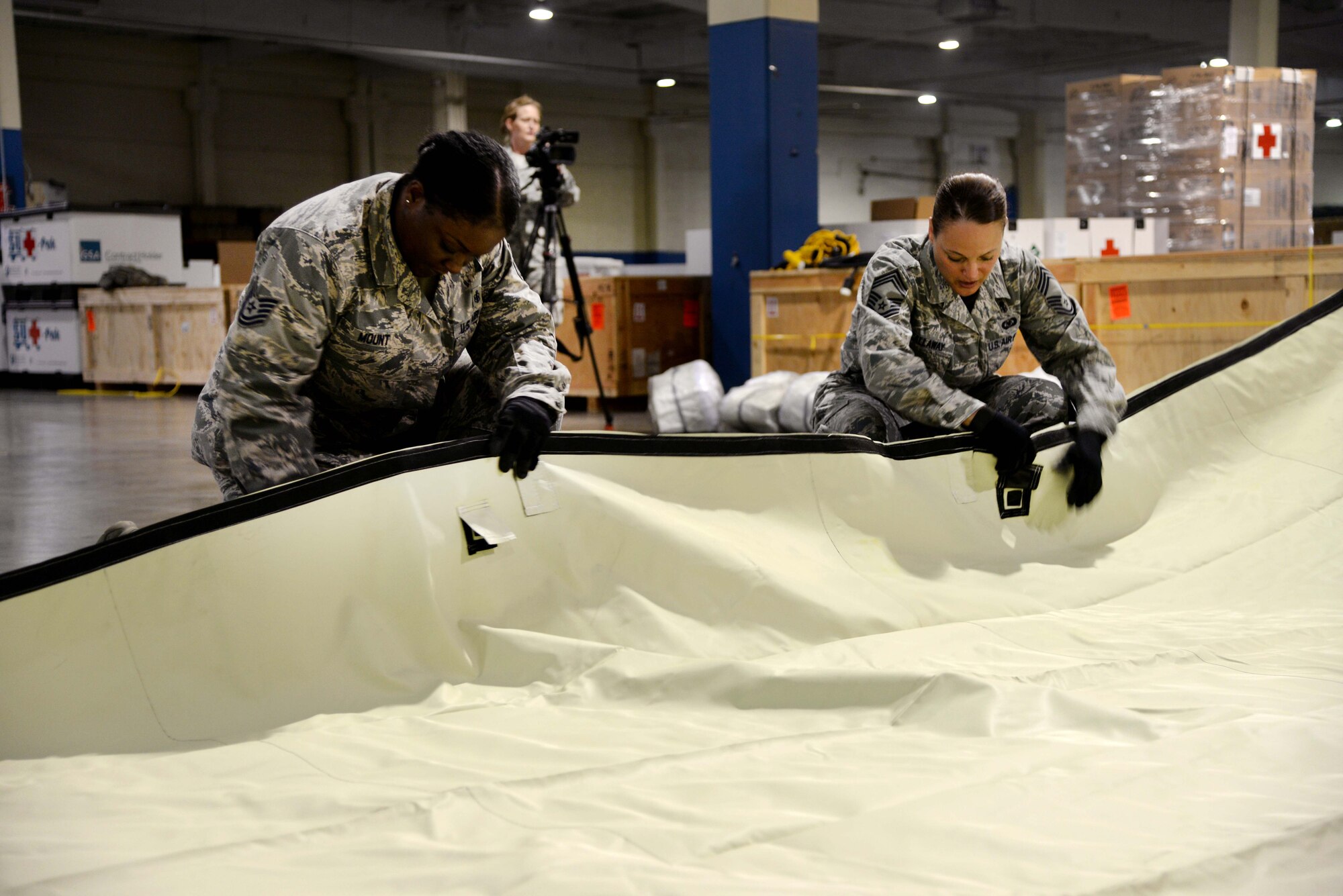 Tech. Sgt. Lakisha Mount, 937th Training Support Squadron, and Chief Master Sgt. Laura Callaway, 559th Medical Group superintendent, secure the tarp of an Alaskan Shelter tent during a tent-building exercise July 21, 2014 on Port San Antonio, Texas. The exercise served as training for the wing’s Defense CBRN Response Force. The team is tasked to provide medical support in the event of a major natural disaster or attack occurring within the U.S. (U.S. Air Force photo/Staff Sgt. Jerilyn Quintanilla)
