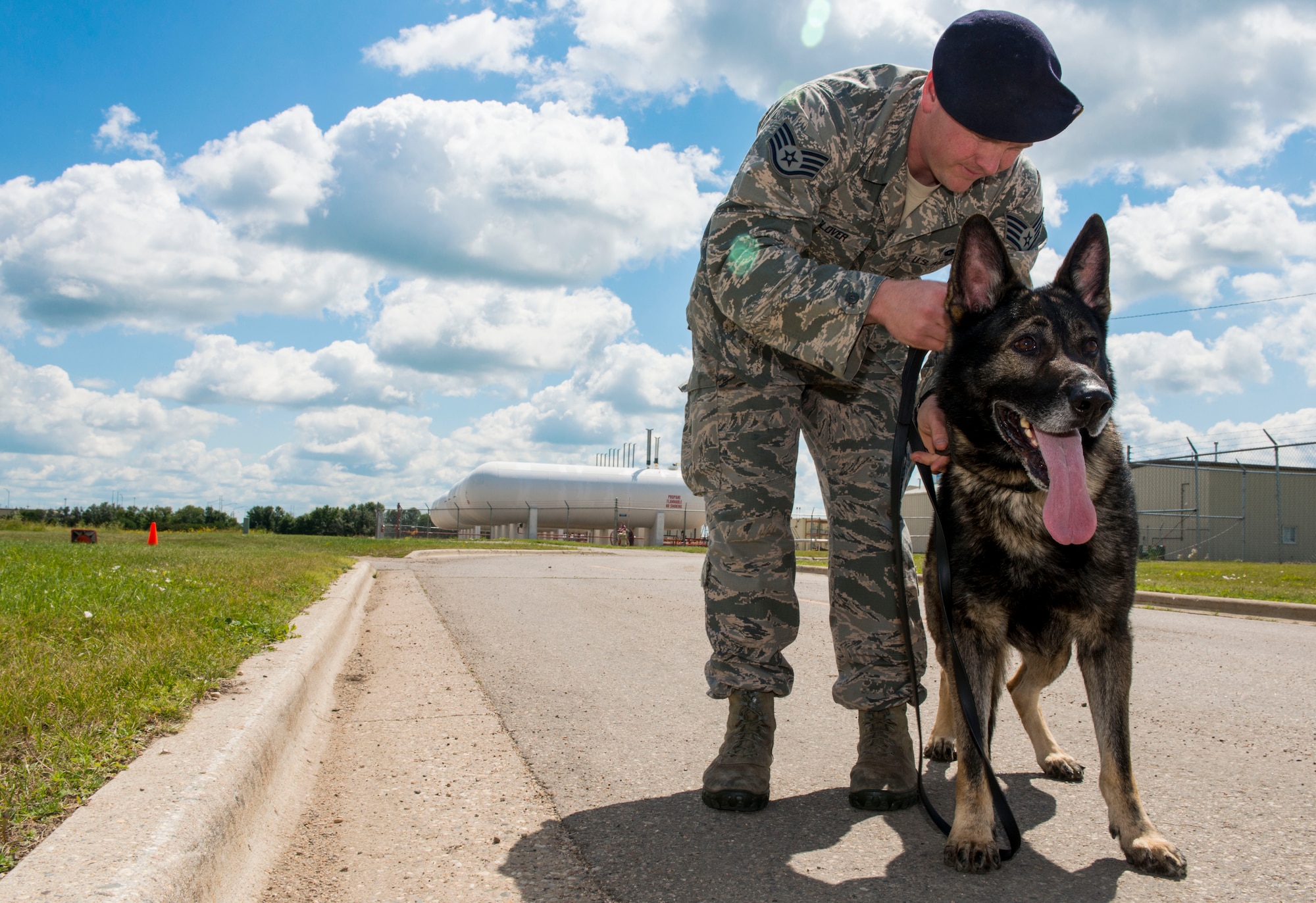Staff Sgt. Tim Glover, 5th Security Forces Squadron military working dog handler, attaches a leash to the collar of his MWD Roko before a walk near the kennels on Minot Air Force Base, N.D., July 28, 2014. Handlers spend a lot of time bonding and building trust with their dogs when they are new to their duty station to create a cohesive team. (U.S. Air Force photo/Senior Airman Stephanie Morris)