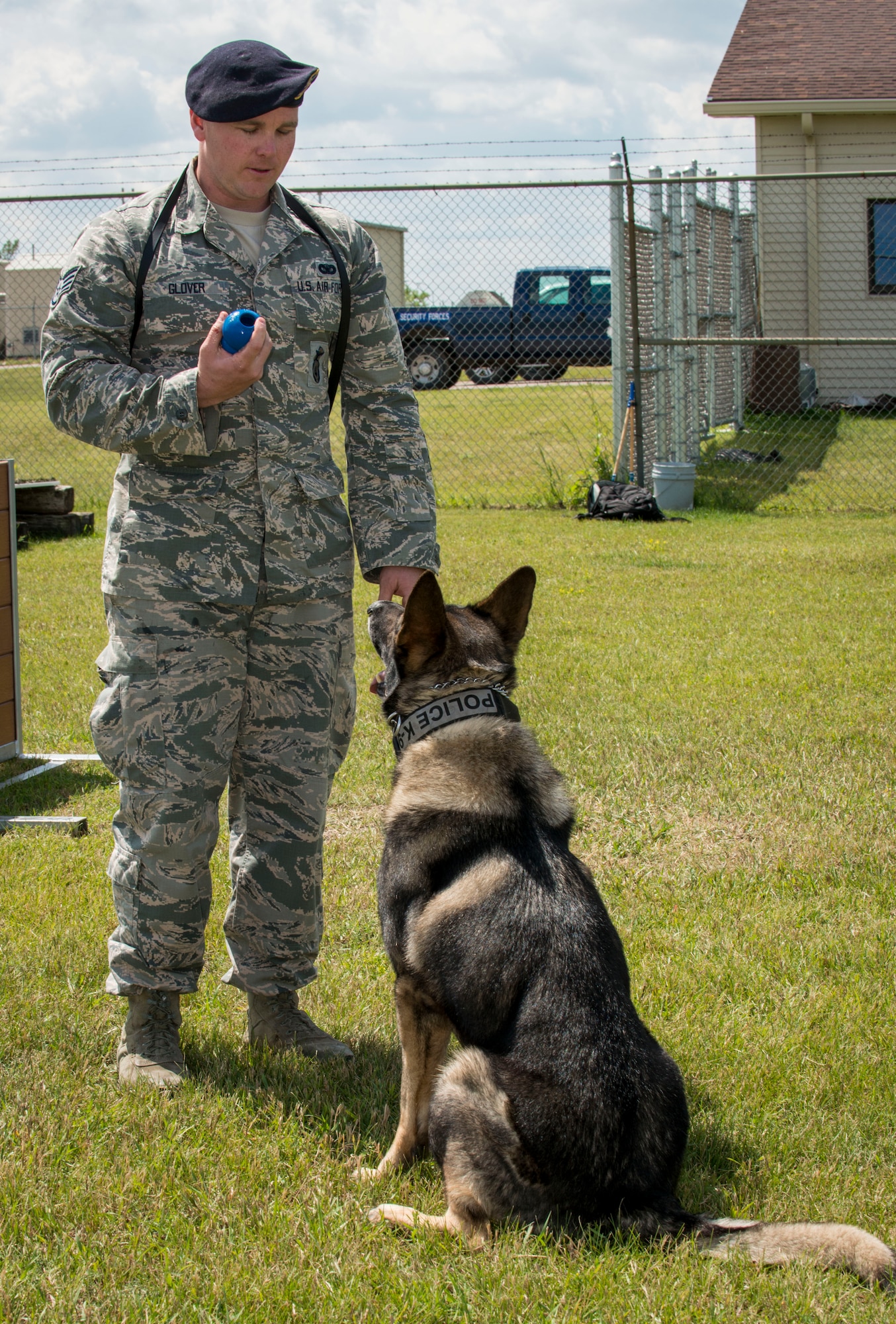 Staff Sgt. Tim Glover, 5th Security Forces Squadron military working dog handler, prepares to throw a toy for his MWD Roko during a game of fetch at the kennels on Minot Air Force Base, N.D., July 28, 2014. Playing games and going for walks with his dog enables Glover to build trust and a strong rapport with Roko. (U.S. Air Force photo/Senior Airman Stephanie Morris)