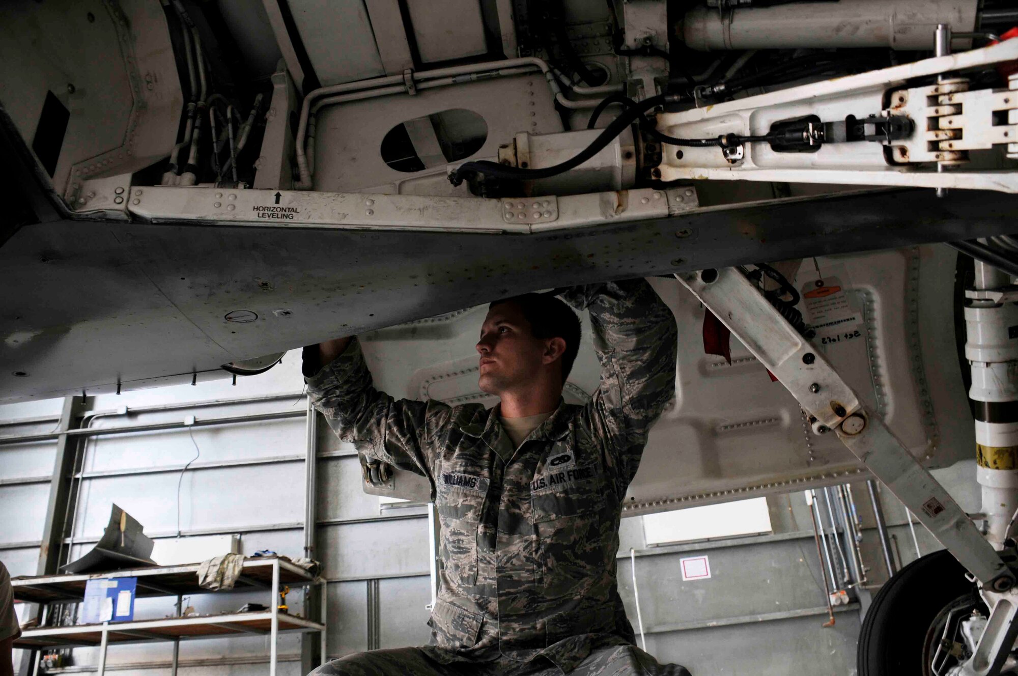 Senior Airmen Jacob Williams 495 Fighter Group of Det. 93 inspects the landing gear of an F-16C at Homestead Air Reserve Base, Fla. Aug. 4. This Airman is a part of the Total Force Integration initiative that trains active-duty and reserve Airmen together to cut cost. (U.S. Air Force photo by/Senior Airman Aja Heiden) 