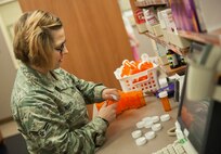 Airman 1st Class Hayley Martin, 5th Medical Support Squadron pharmacy technician, caps prescriptions on Minot Air Force Base, N.D., July 30, 2014. The pharmacy provides services to over 12,000 Minot AFB beneficiaries. (U.S. Air Force photo/Airman 1st Class Apryl Hall)