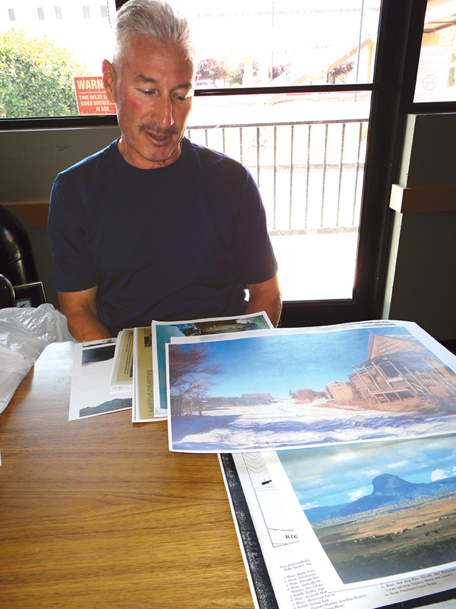 Retired Army Lt. Col.Michael Tachias looks at photos of the ghost town near Cabezon
Peak. He is building a retreat there for combat veterans. (Photo by Ryan Stark)