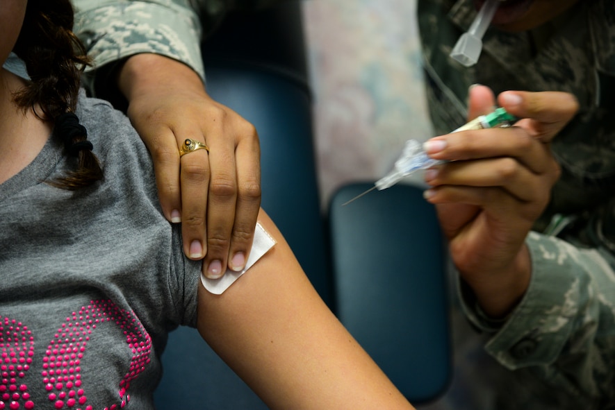U.S. Air Force Airman 1st Class Gelisa Adams, 23d Medical Operations Squadron allergy and immunizations technician, vaccinates Kaityln Nelson, daughter of Tech. Sgt. Thomas Nelson, at Moody Air Force Base, Ga., July 30, 2014. Moody’s immunization clinic is open to dependents enrolled in the facility, active-duty members and retirees Monday to Friday on a walk-in basis. The clinic vaccinates Department of Defense and civilian contractors per job requirements. (U.S. Air Force photo by Airman 1st Class Sandra Marrero/Released)
