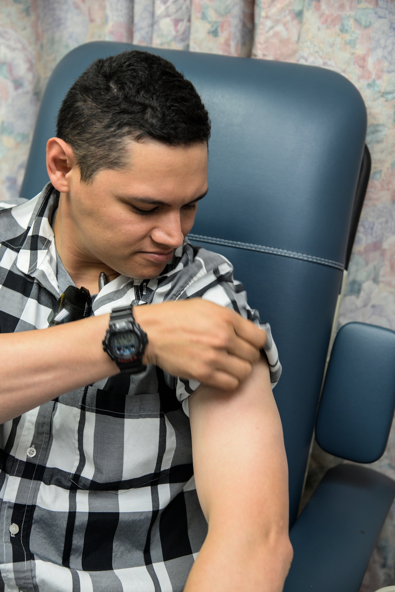 U.S. Air Force Staff Sgt. Christopher White, 23d Security Forces Squadron response force leader, looks at his arm after receiving an immunization at Moody Air Force Base, Ga., July 30, 2014. White received an anthrax immunization in preparation for a permanent change of station to Osan Air Base, Republic of Korea. (U.S. Air Force photo by Airman 1st Class Sandra Marrero/Released)
