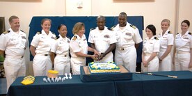 Capt. Julie Miavez, Naval Health Clinic Charleston optometrist, and Lt. j.g. Fred Nti, NHCC Materiel Management Department head, cut a cake in honor of the Navy Medical Service Corps 67th birthday Aug. 4, 2014, in the NHCC atrium. Also in attendance were (left to right) Capt. Daniel Denton, Lt. Lauren Brown, Lt. j.g. Teckolar Seals, Capt.Julie Miavez, Lt. j.g. Fred Nti, Capt. Marvin Jones, NHCC commanding officer, Lt.j.g. Danielle Donnelly, Lt. Brittany Haden and Lt. Crystal Massey. (U.S. Navy photo/Seaman Cody Meeks)
