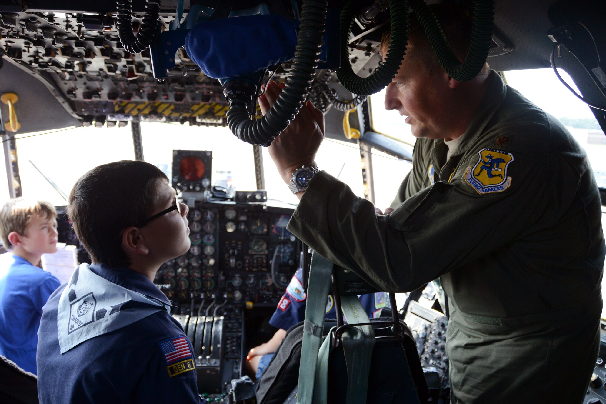 Maj. Kevin Eikleberry, pilot for the 118th Airlift Squadron, explains the various functions of the C-130H aircraft controls to a very intent Anthony Maio, 9, as Blake Kamoen, 8, listens in. Behind Eikleberry in the co-pilot seat is Tristan Schemmerling, 8. All three of the children are part of Cub Scout Troop 18 and came to the Bradley Air National Guard Base, East Granby, Conn., Aug. 4, 2014, to take a tour of the unit’s recently assigned aircraft. (U.S. Air National Guard photo by Tech. Sgt. Joshua Mead/Released)