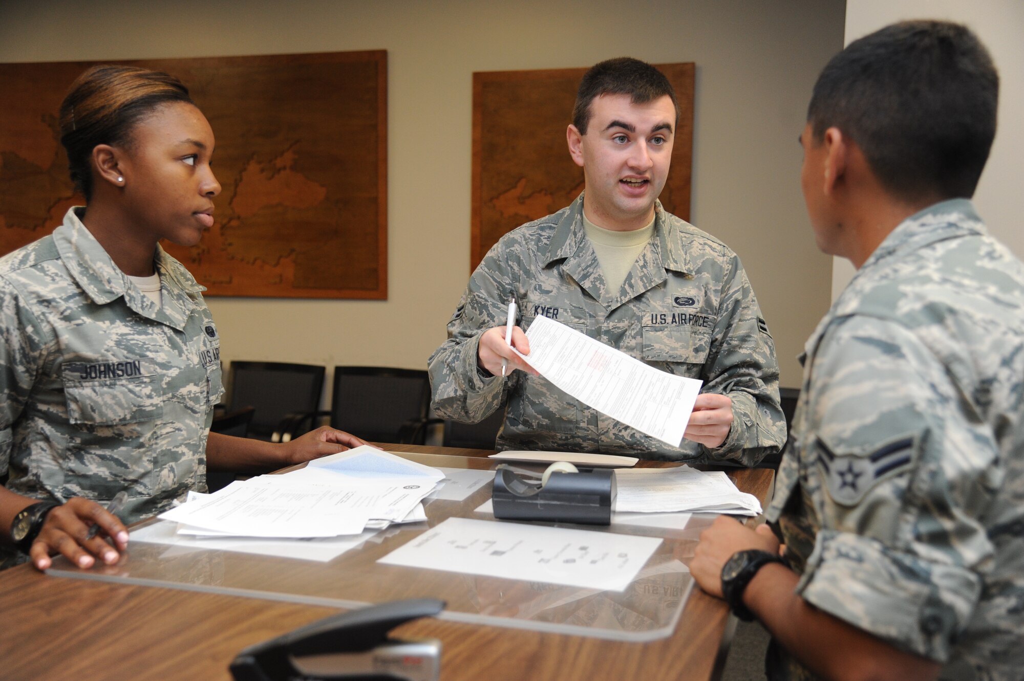 Airman 1st Class Joshua Kyer, 81st Force Support Squadron, (center), out-processes Airman Chacondria Johnson and David Nunez, 336th Training Squadron, Aug. 5, 2014, at the Levitow Training Support Facility, Keesler Air Force Base, Miss.  Kyser says he joined the Air Force to honor his father’s wish for military service.  (U.S. Air Force photo by Kemberly Groue)