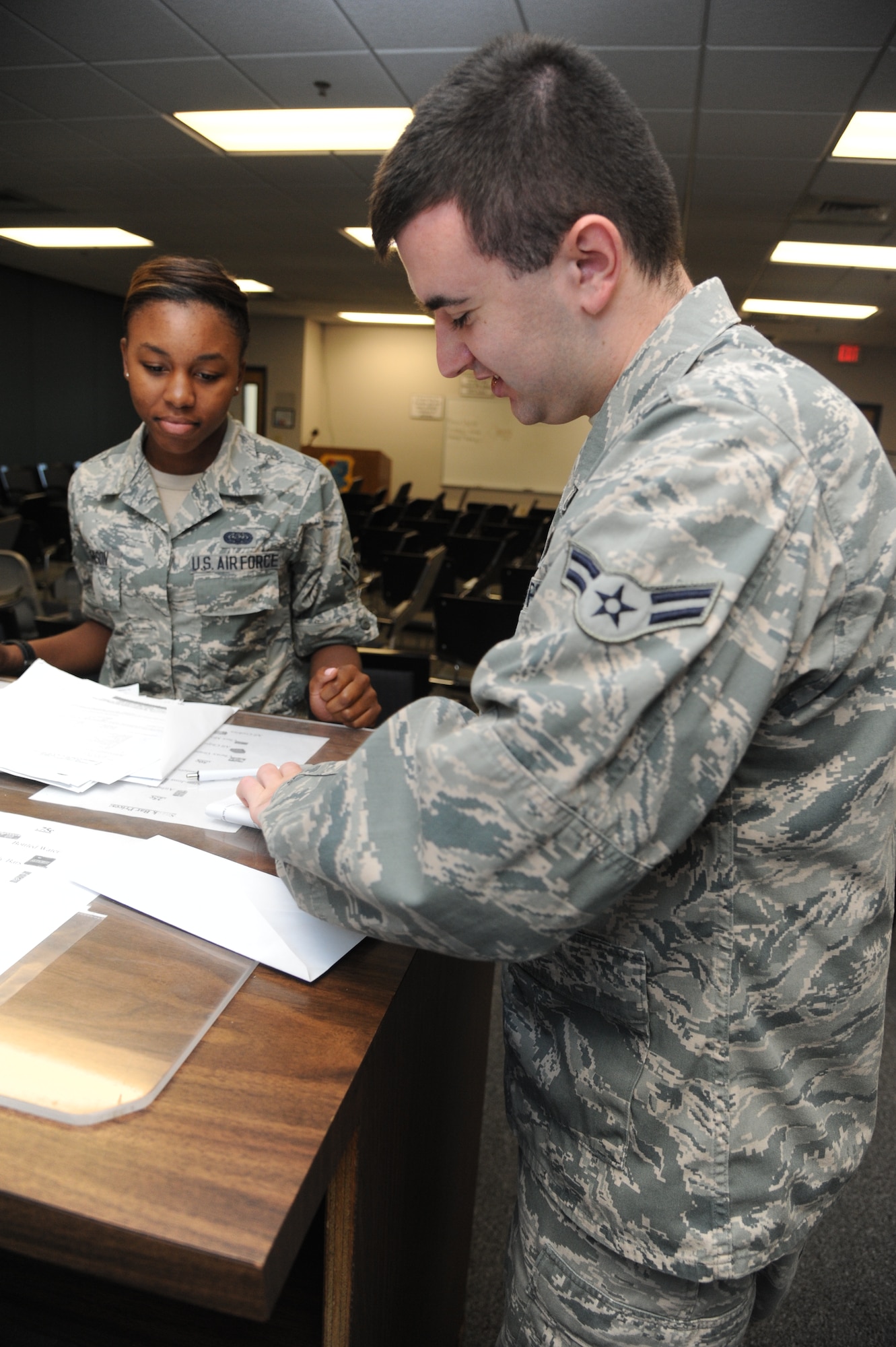 Airman Chacondria Johnson, 336th Training Squadron, is out-processed by Airman 1st Class Joshua Kyer, 81st Force Support Squadron, Aug. 5, 2014, at the Levitow Training Support Facility, Keesler Air Force Base, Miss.  Kyser says he joined the Air Force to honor his father’s wish for military service.  (U.S. Air Force photo by Kemberly Groue)