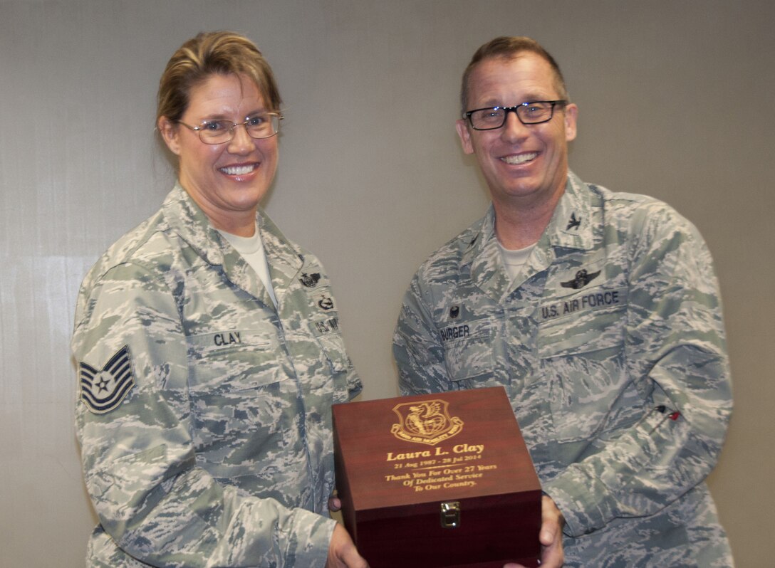 TRAVIS AIR FORCE BASE, Calif. -- Col. Matthew Burger, 349th Air Mobility Wing commander presents an engraved wooden keepsake box to Tech. Sgt. Laura Clay, 349th Wing historian, upon the occasion of her retirement, July 26, 2014. (U.S Air Force photo / Staff Sgt. Cindy Alejandrez)
