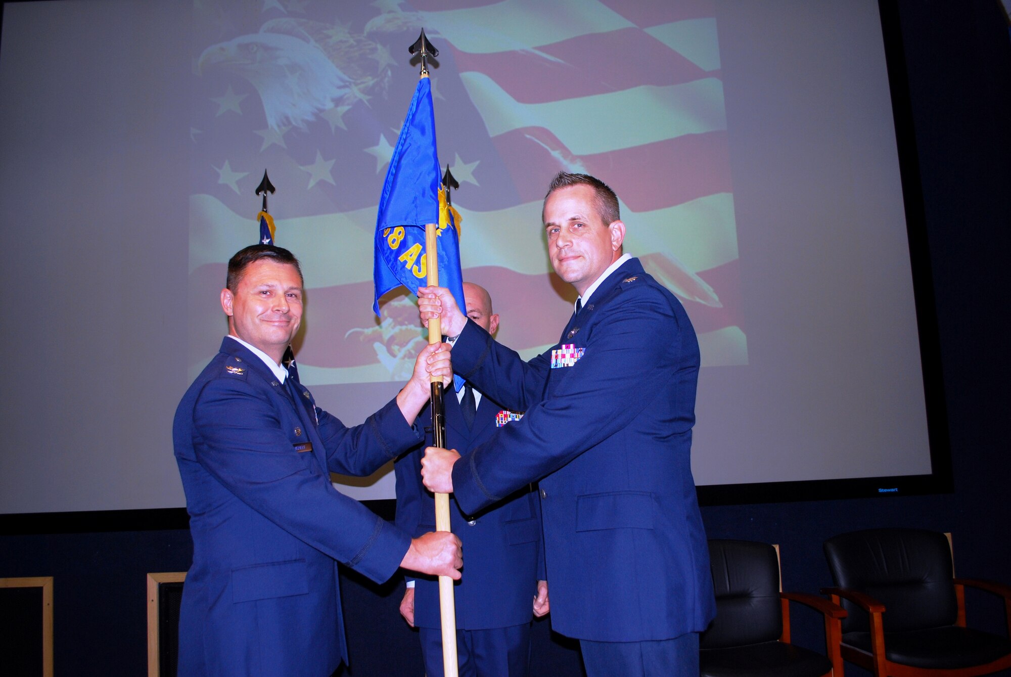 Col. Lee E. Murkle hands Lt. Col. Marc D. Mulkey the 68th Airlift Squadron flag during an Assumption of Command ceremony on August 2, 2014 at Joint Base San Antonio-Lackland, Texas. 
