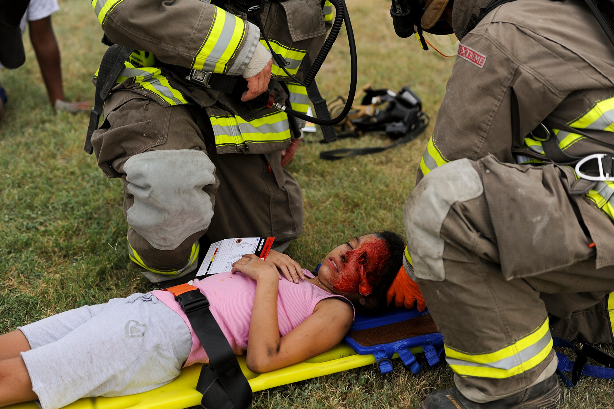 SAN ANGELO, Texas – Zoe R. Mild, volunteer victim, lies on a stretcher while San Angelo Fire Department personnel strap her in during a military and civilian joint training exercise at Mathis Field July 31. The exercise involved a simulated military vs civilian aircraft collision. (U.S. Air Force photo/ Airman 1st Class Devin Boyer)