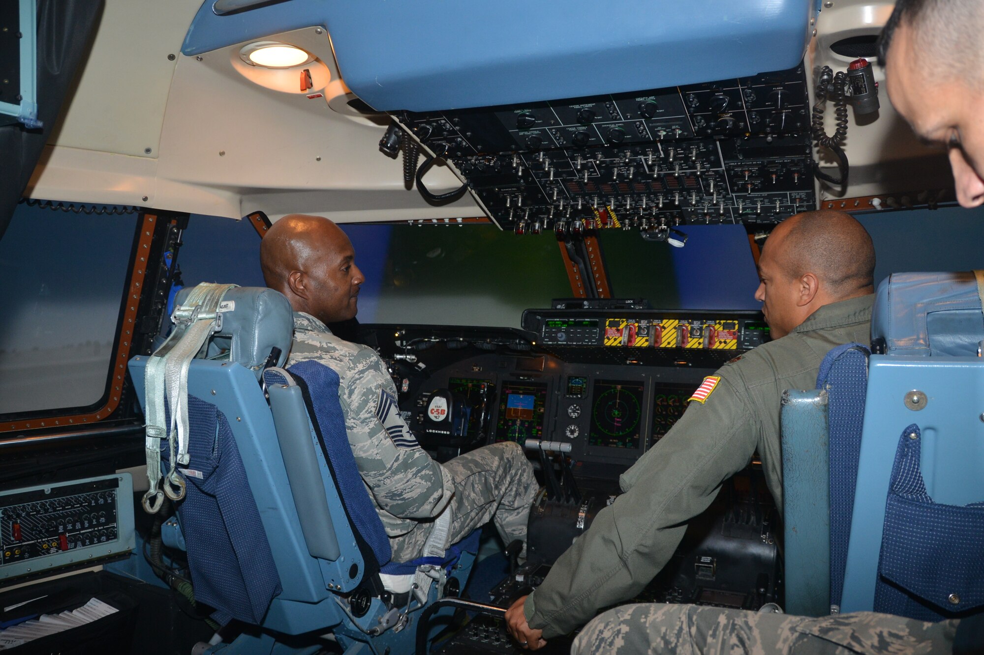 Maj. Makia Epie(right), pilot instructor, 733rd Training Squadron, Joint Base San Antonio-Lackland, Texas, teaches simulator controls to Command Chief Master Sgt. Cameron Kirksey, Air Force Reserve Command, Robins Air Force Base, Georgia, during a base visit to Lackland, August 1, 2014. (U.S. Air Force photo by Minnie Jones)