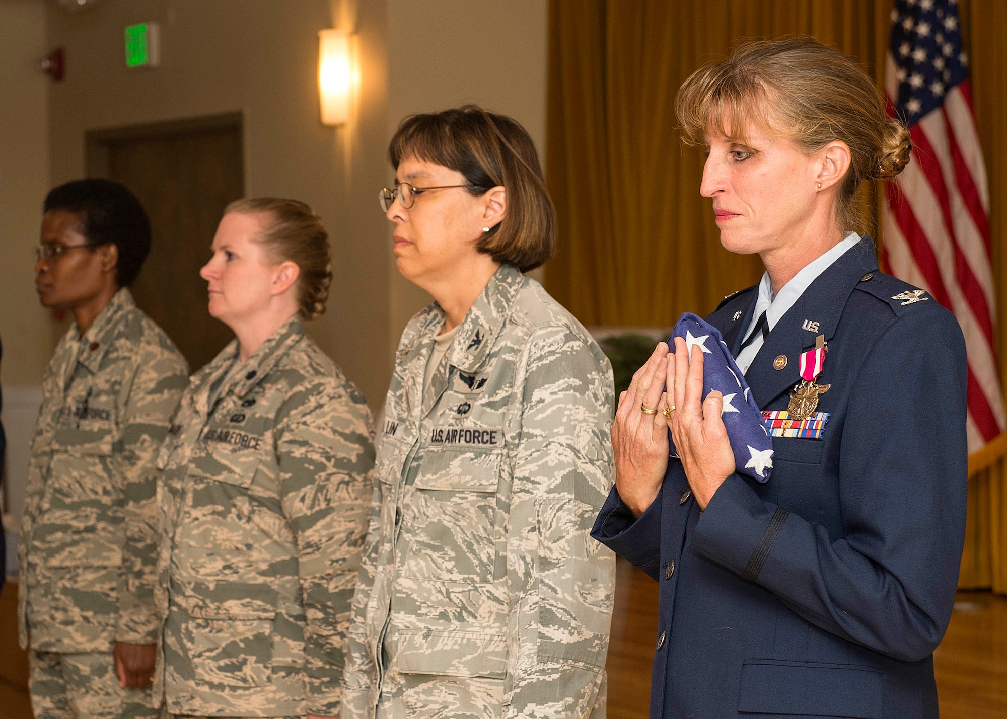 Col. Tammy Smeeks embraces the American Flag after it was presented to her during her retirement ceremony July 31 at Club Muroc. Smeeks retired after 30 years in the Air Force. (U.S. Air Force photo by Edward Cannon)