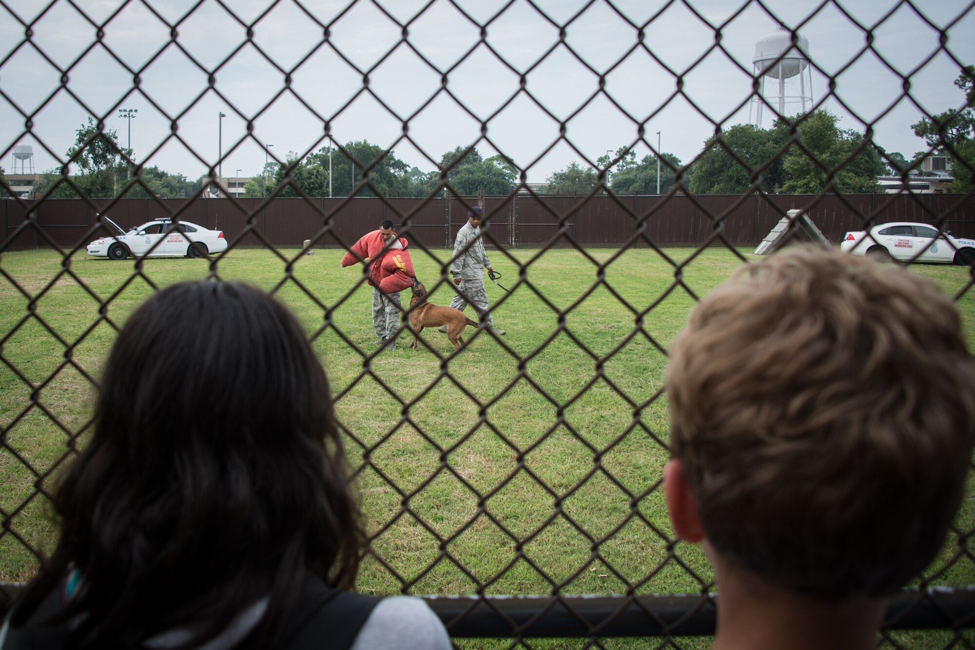 Staff Sgt. Kyle Smith and his military working dog, Densy, apprehend Senior Airman Jonathan Gallardo-Reyes, 81st Security Forces Squadron, as he portrays a “bad guy”  during a demonstration for children of Keesler personnel Aug. 1, 2014, at the K-9 facility, Keesler Air Force Base, Miss. Children from the child development center and the youth center participated in the tour.  (U.S. Air Force photo by Marie Floyd)
