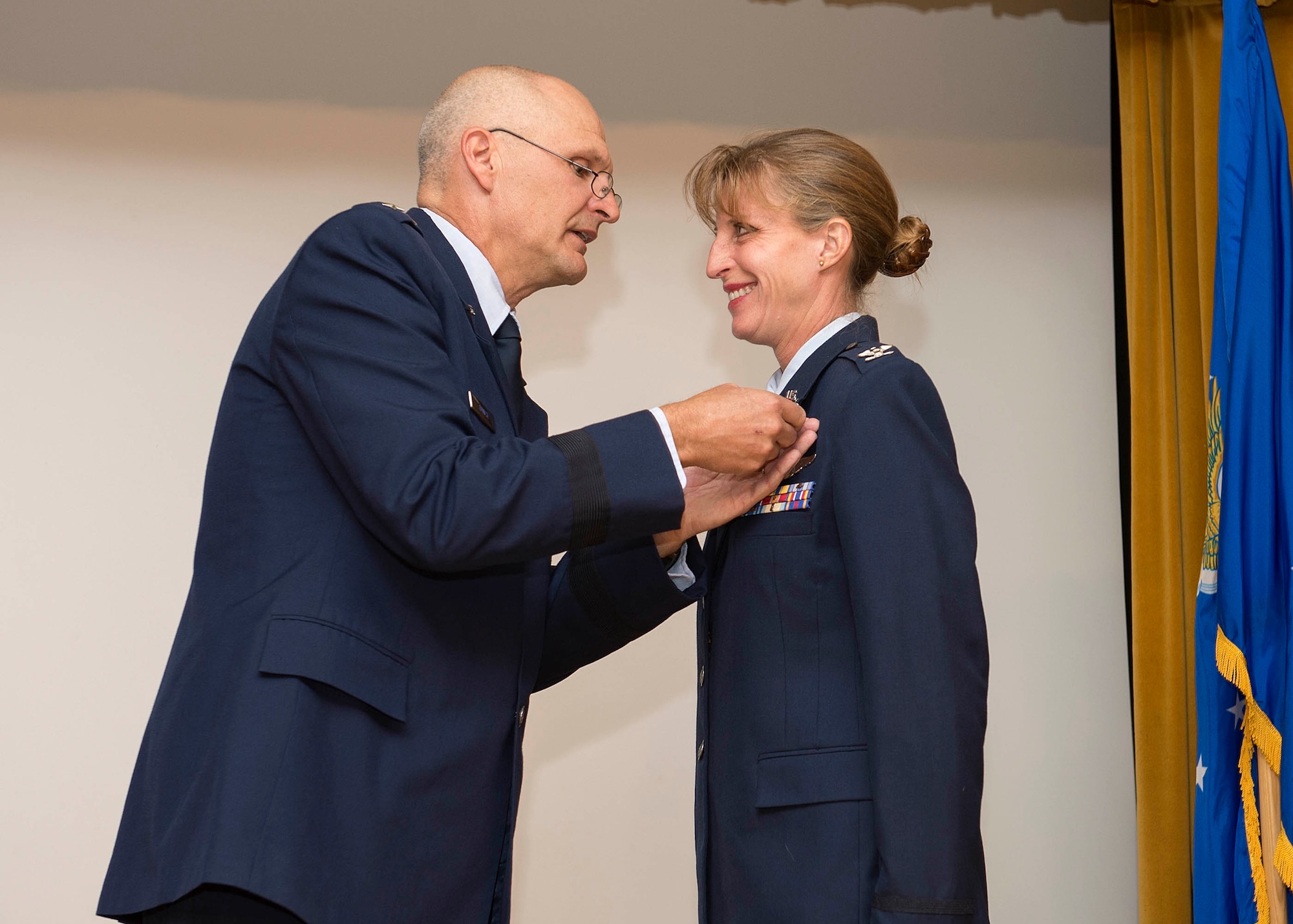 Col. Tammy Smeeks, 412th Mission Support Group, is presented with a retirement pin by Maj. Gen. Arnold Bunch Jr., Air Force Test Center commander, during a retirement ceremony held in her honor July 31 at Club Muroc. Smeeks will continue her service at Edwards as a civilian supervisor for Force Development Program and Training for the center. (U.S. Air Force photo by Edward Cannon)