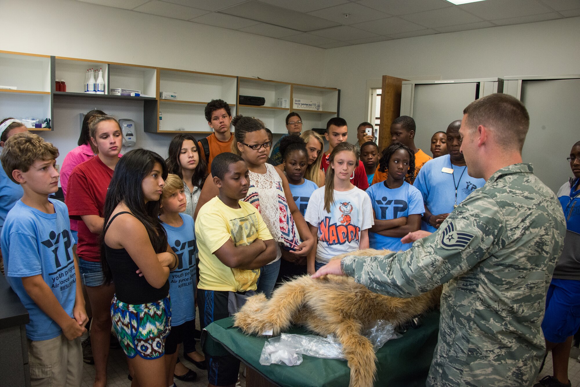 Staff Sgt. James Martin, 81st Security Forces Squadron, explains to children of Keesler personnel how a simulated dog is used to practice veterinary procedures for military working dogs at the K-9 facility Aug. 1, 2014, at Keesler Air Force Base, Miss. Children from the child development center and the youth center participated in the tour.  (U.S. Air Force photo by Marie Floyd)
