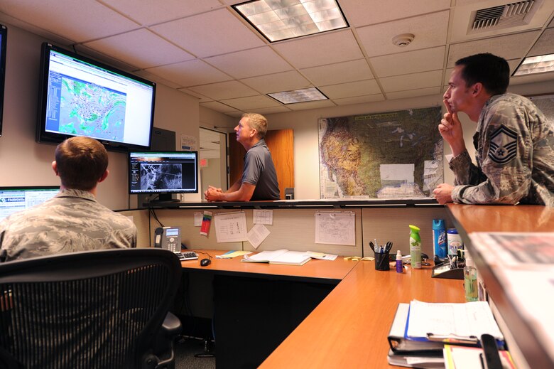 Airmen from the 92nd Operations Support Squadron discuss the weather forecast for the day during their daily operation risk management at Fairchild Air Force Base, Washington, July 18, 2014. Ensuring safe weather conditions is one of the first steps before accomplishing any refueling or rescue missions. (U.S. Air Force photo by Airman 1st Class Janelle Patiño/Released)