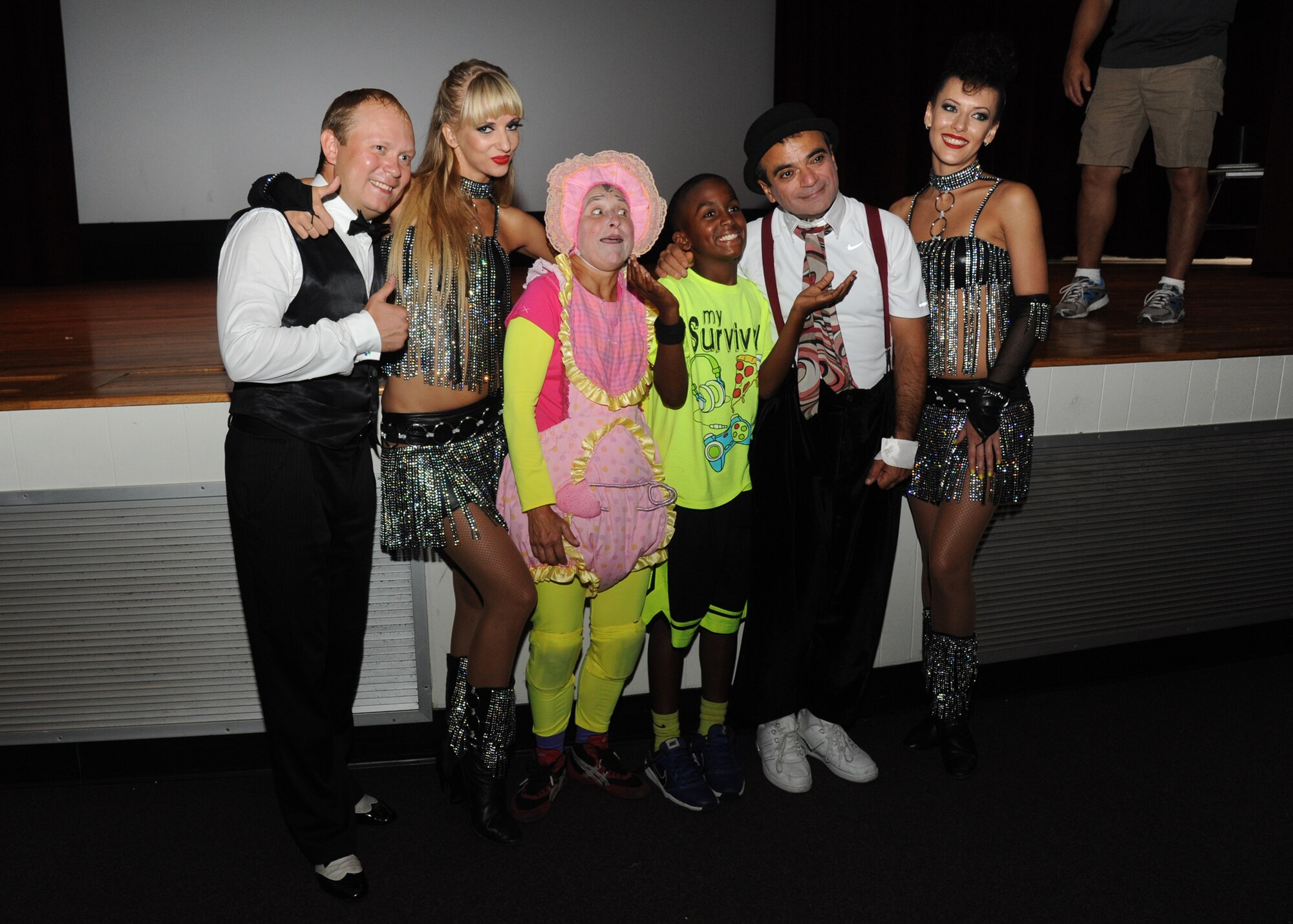 The son of Senior Master Sgt. Glenn Branch, 81st Diagnostic and Therapeutics Squadron, takes a group photo with Saltoriya performers following a military appreciation show Aug. 1, 2014, at the Welch Theater, Keesler Air Force Base, Miss.  Saltoriya features some of the best international aerialists and artists who perform gravity-defying feats. (U.S. Air Force photo by Kemberly Groue)