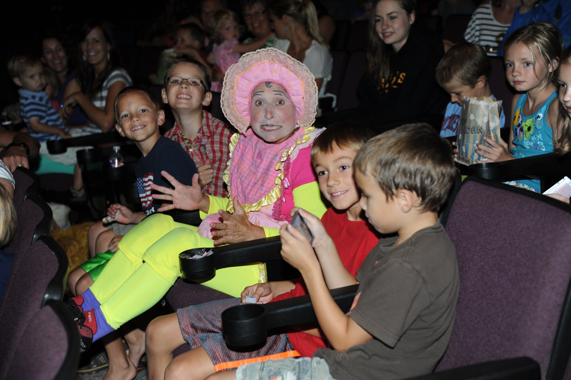 A Saltoriya performer, portraying a wandering baby, sits among Keesler family members during a military appreciation show Aug. 1, 2014, at the Welch Theater, Keesler Air Force Base, Miss.  Saltoriya features some of the best international aerialists and artists who perform gravity-defying feats. (U.S. Air Force photo by Kemberly Groue)