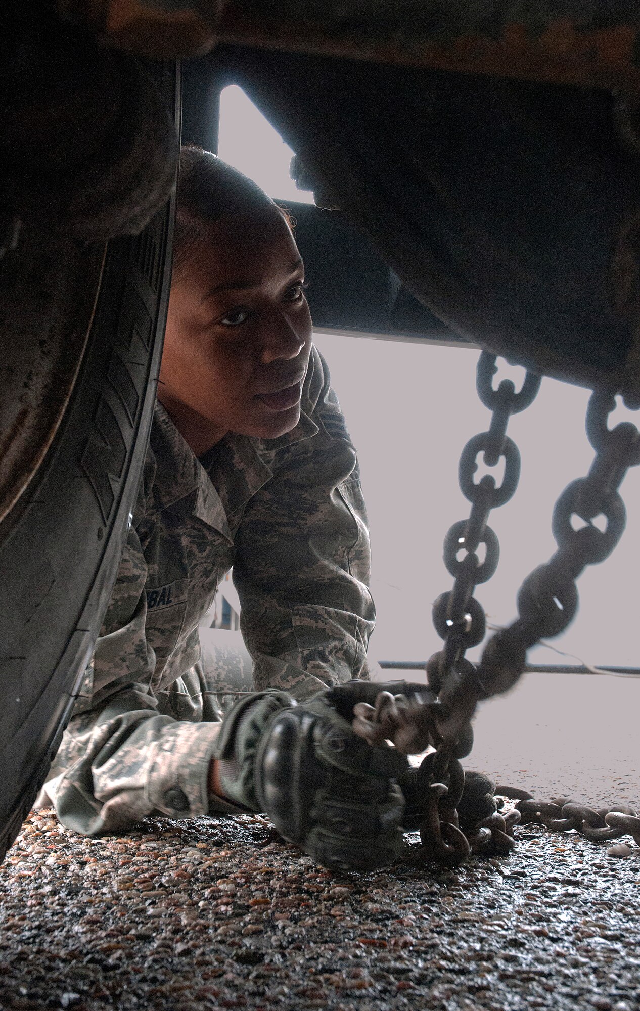 Senior Airman Dorothy Hannibal, 90th Logistics Readiness Squadron vehicle operations, connects a chain to the underside of an M. Van July 30, 2014, at vehicle maintenance on F.E. Warren Air Force Base. The van being prepped for transport for repairs to its transmission. (U.S. Air Force photo by Airman Malcolm Mayfield)