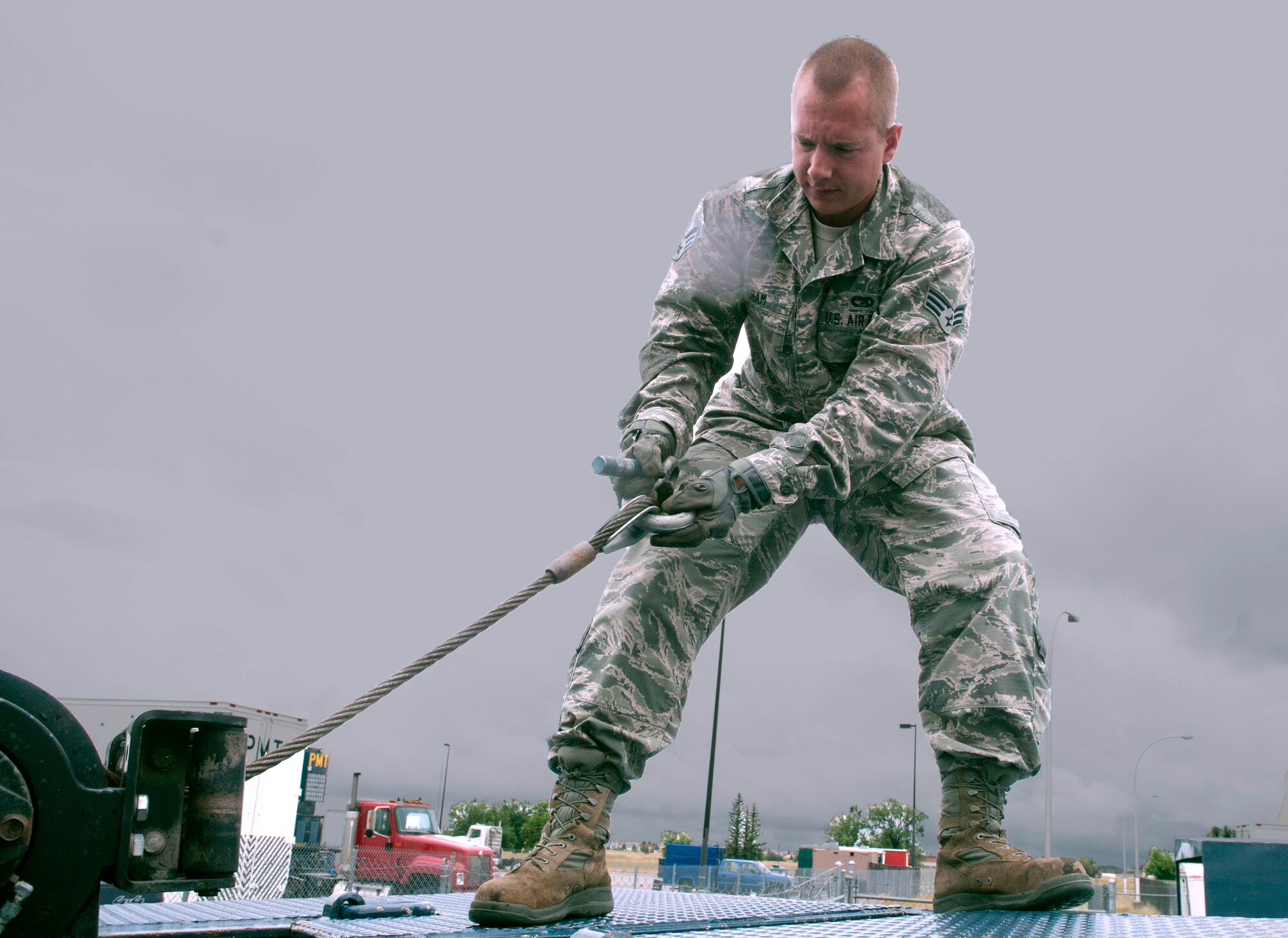 Senior Airman Richard Cram, 90th Logistics Readiness Squadron vehicle operations, extends a cable connected to a slide axle trailer July 30, 2014, on F.E. Warren Air Force Base. Vehicle operations use slide axle trailers for transporting vehicles off base for repairs. (U.S. Air Force photo by Airman Malcolm Mayfield)