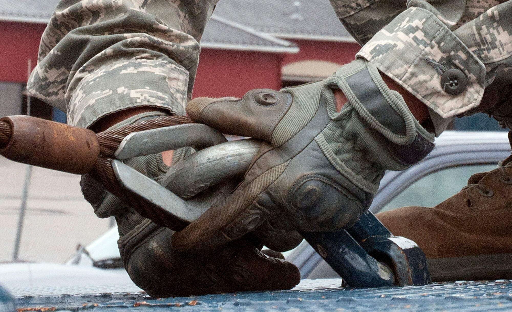 Senior Airman Richard Cram, 90th Logistics Readiness Squadron vehicle operations, unbuckles a cable connected to a slide axle trailer July 30, 2014, at the vehicle maintenance building on F.E. Warren Air Force Base. Vehicle operations is responsible for making repair runs for vehicles when a third party is required. (U.S. Air Force photo by Airman Malcolm Mayfield)