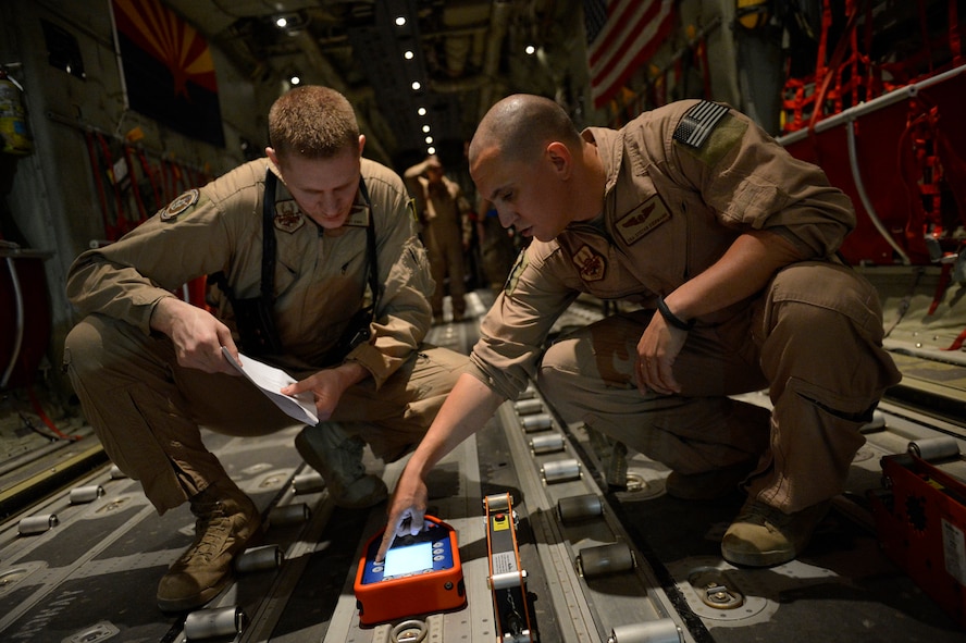 (From left) U.S. Air Force Senior Airmen Korey King and Stefan Eiermann, 774th Expeditionary Airlifit Squadron loadmasters program the Wireless Gate Release System before an airdrop at Bagram Airfield, Afghanistan Aug. 1, 2014. The squadron completed an airdrop for the Afghan National Army using the new WGRS.  The WGRS helps keep loadmasters safe and saves the Air Force money in material costs. King is deployed from Dyess Air Force Base, Texas and a native of Hudson, Fla. Eiermann is deployed from Dyess Air Force Base, Texas and a native of Corpus Christi, Texas. (U.S. Air Force photo by Staff Sgt. Evelyn Chavez/Released)