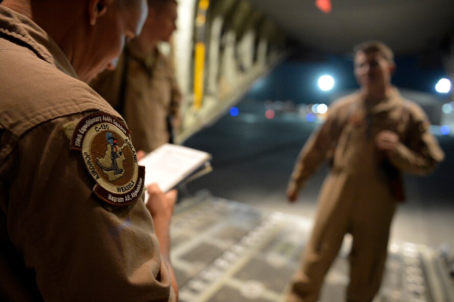 U.S. Air Force Stefan Eiermann, 774th Expeditionary Airlifit Squadron loadmaster reviews a checklist before an airdrop at Bagram Airfield, Afghanistan Aug. 1, 2014.  Loadmasters are using a new system for airdrops, the Wireless Gate Release System keeps them safely behind payloads exiting the aircraft. Eiermann is deployed from Dyess Air Force Base, Texas and a native of Corpus Christi, Texas.(U.S. Air Force photo by Staff Sgt. Evelyn Chavez/Released)