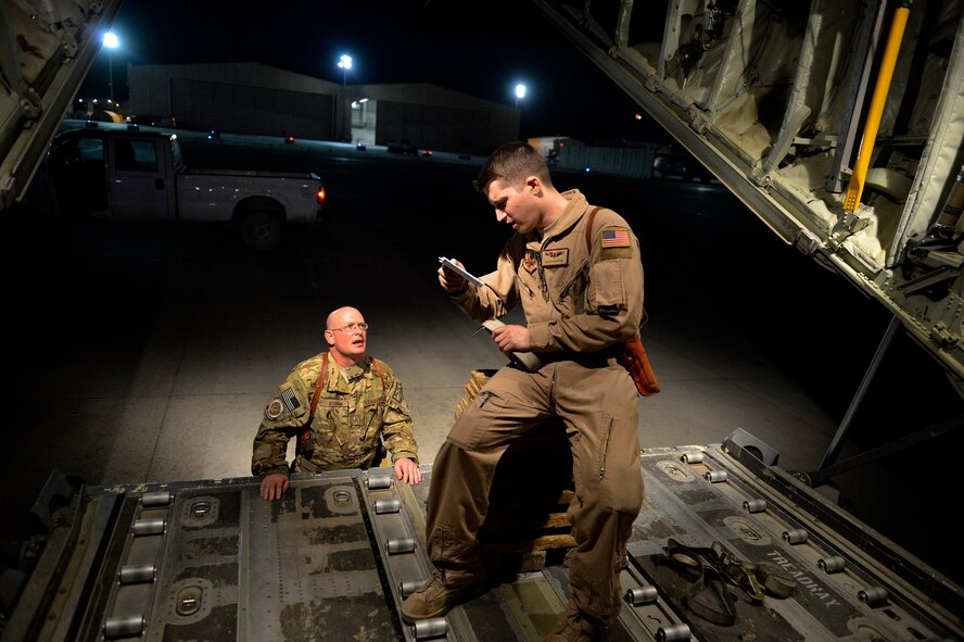 (From left) U.S. Air Force Master Sgt. Bradley Nulf, 774th Expeditionary Airlift Squadron evaluator loadmaster and Senior Airmen David Payne, 774 EAS loadmaster review directions before an airdrop at Bagram Airfield, Afghanistan Aug. 1, 2014.  The squadron completed an airdrop for the Afghan National Army using the newly Wireless Gate Release System.  Nulf is deployed from Dyess Air Force Base, Texas and a native of Columbia City, Ind. Payne is deployed from Dyess Air Force Base, Texas and a native of Gilbert, Ariz.  (U.S. Air Force photo by Staff Sgt. Evelyn Chavez/Released)