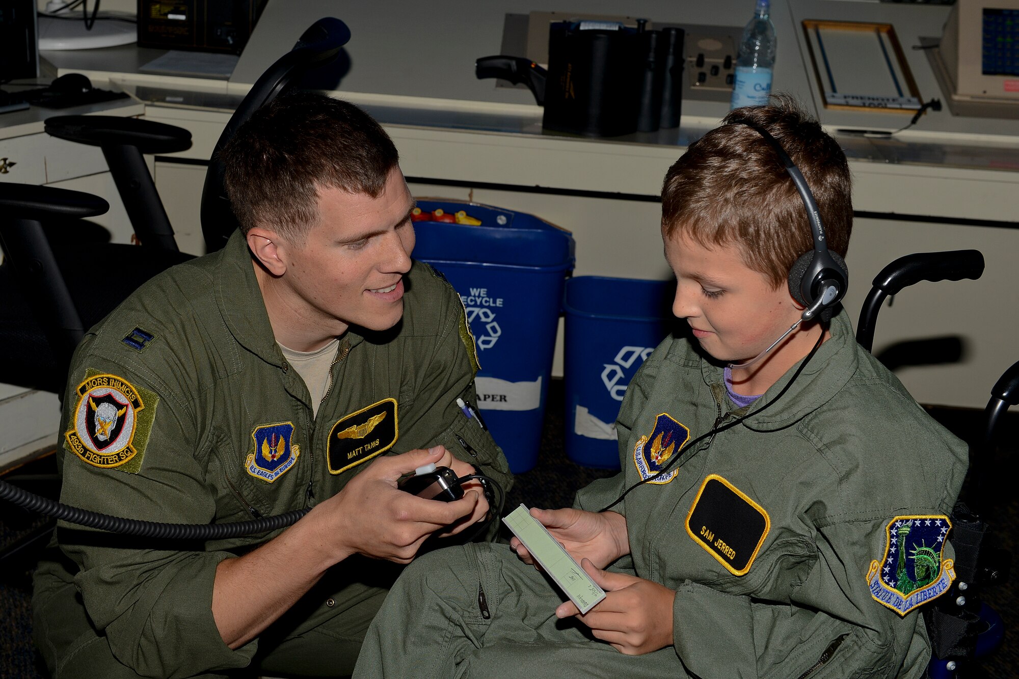 Capt. Matthew Tanis, 493rd Fighter Squadron F-15C Eagle pilot, helps Sam Jerred, 9, speak over the radio to fighter pilots during a “Pilot for a Day” event at Royal Air Force Lakenheath, England, Aug. 4, 2014. The program gives the opportunity for local children with serious illnesses and conditions to learn about the Air Force mission, and it provides them with a day to escape their normal hospital routine. (U.S. Air Force photo by Airman 1st Class Trevor T. McBride/Released)