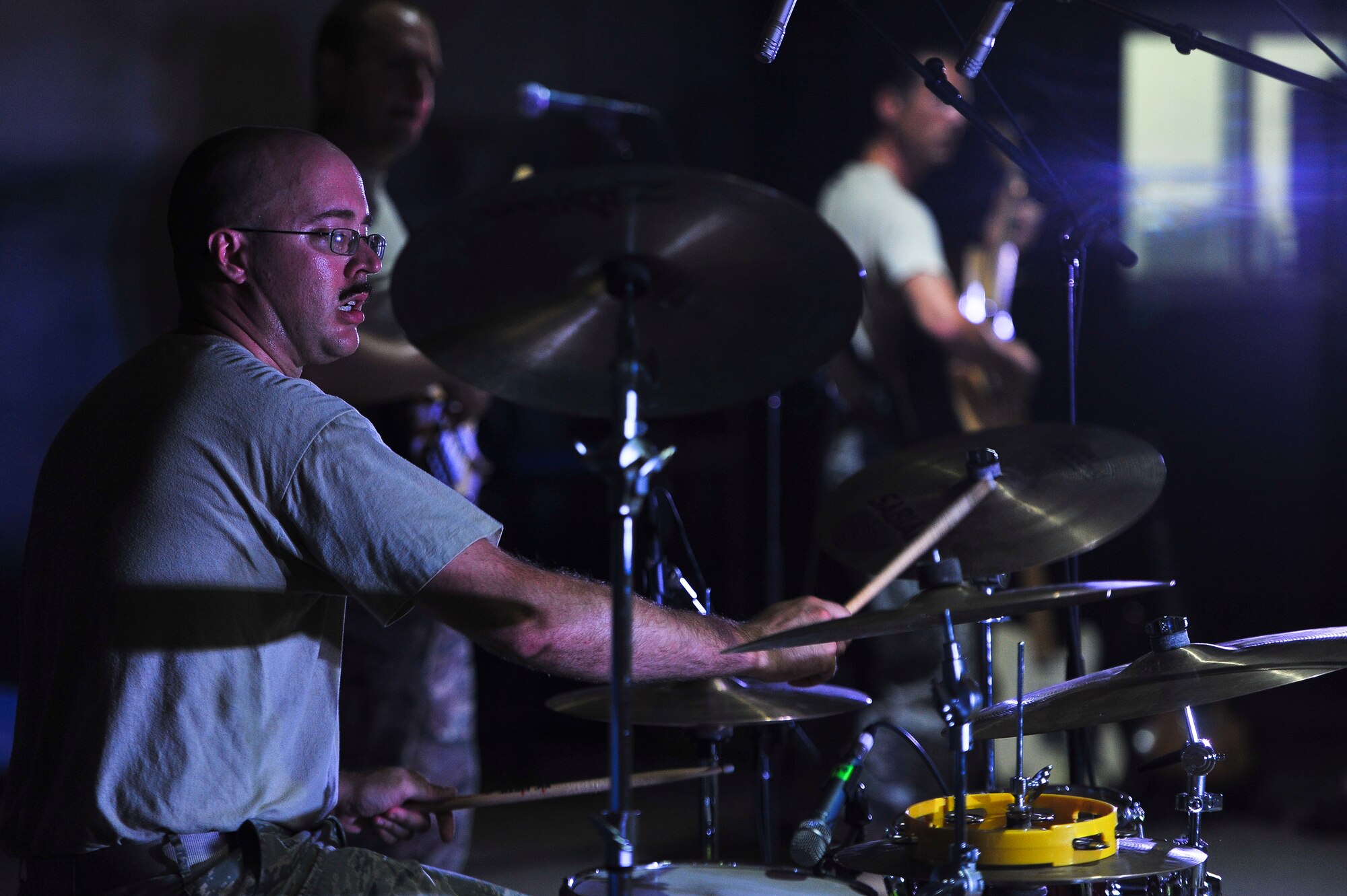 Senior Airman Jon-Marc Dale, an Air Force Central Command Starlifter band member, plays the drums during a visit to the 380th Air Expeditionary Wing Aug. 1, 2014, at an undisclosed location in Southwest Asia. The band played at multiple locations around the base during their visit.  (U.S. Air Force photo by Tech. Sgt. Russ Scalf/Released)