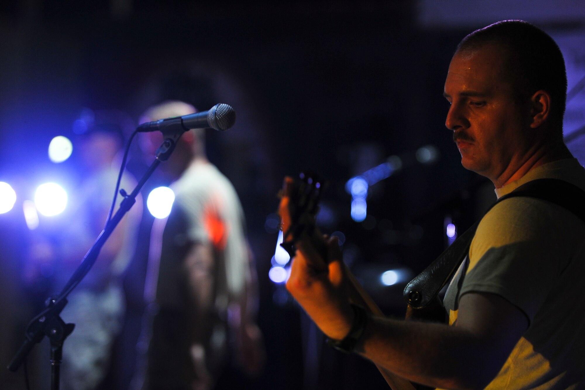 Senior Airman Christopher Haughey, a bass player with the Air Force Central Command Starflifter Band, plays during a visit to the 380th Air Expeditionary Wing Aug. 1, 2014, at an undisclosed location in Southwest Asia. The band played at multiple locations around the base during their visit.  (U.S. Air Force photo by Tech. Sgt. Russ Scalf/Released)