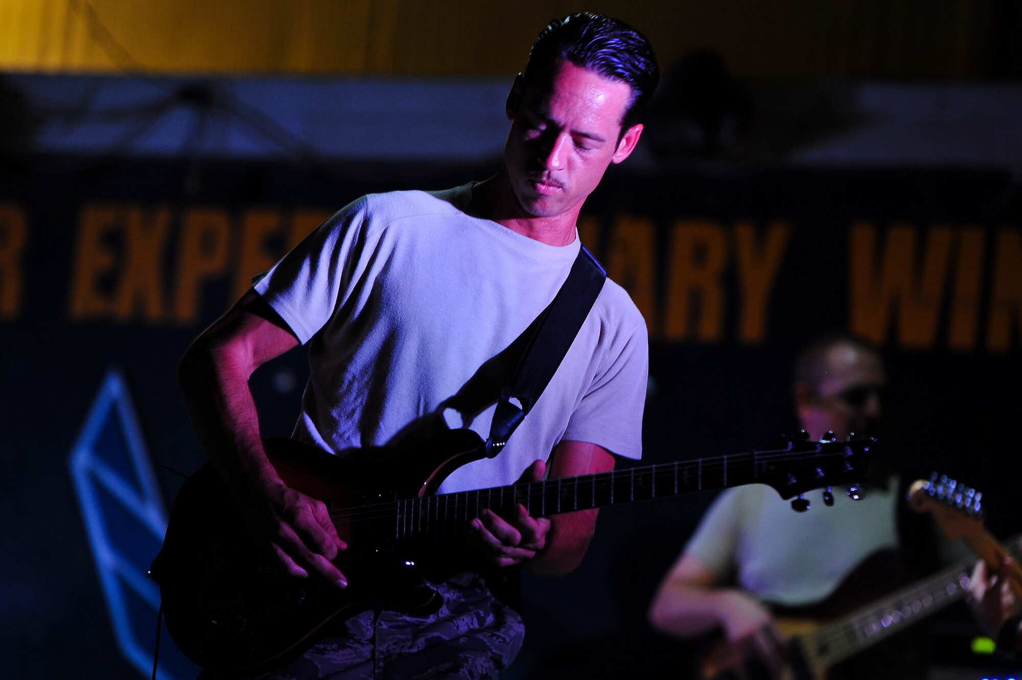 Tech. Sgt. Johnny Kukan, an Air Force Central Command Starflifter Band member, plays the guitar during a performance for the 380th Air Expeditionary Wing Aug. 1, 2014, at an undisclosed location in Southwest Asia. The band played at multiple locations around the base during their visit. (U.S. Air Force photo by Tech. Sgt. Russ Scalf/Released)