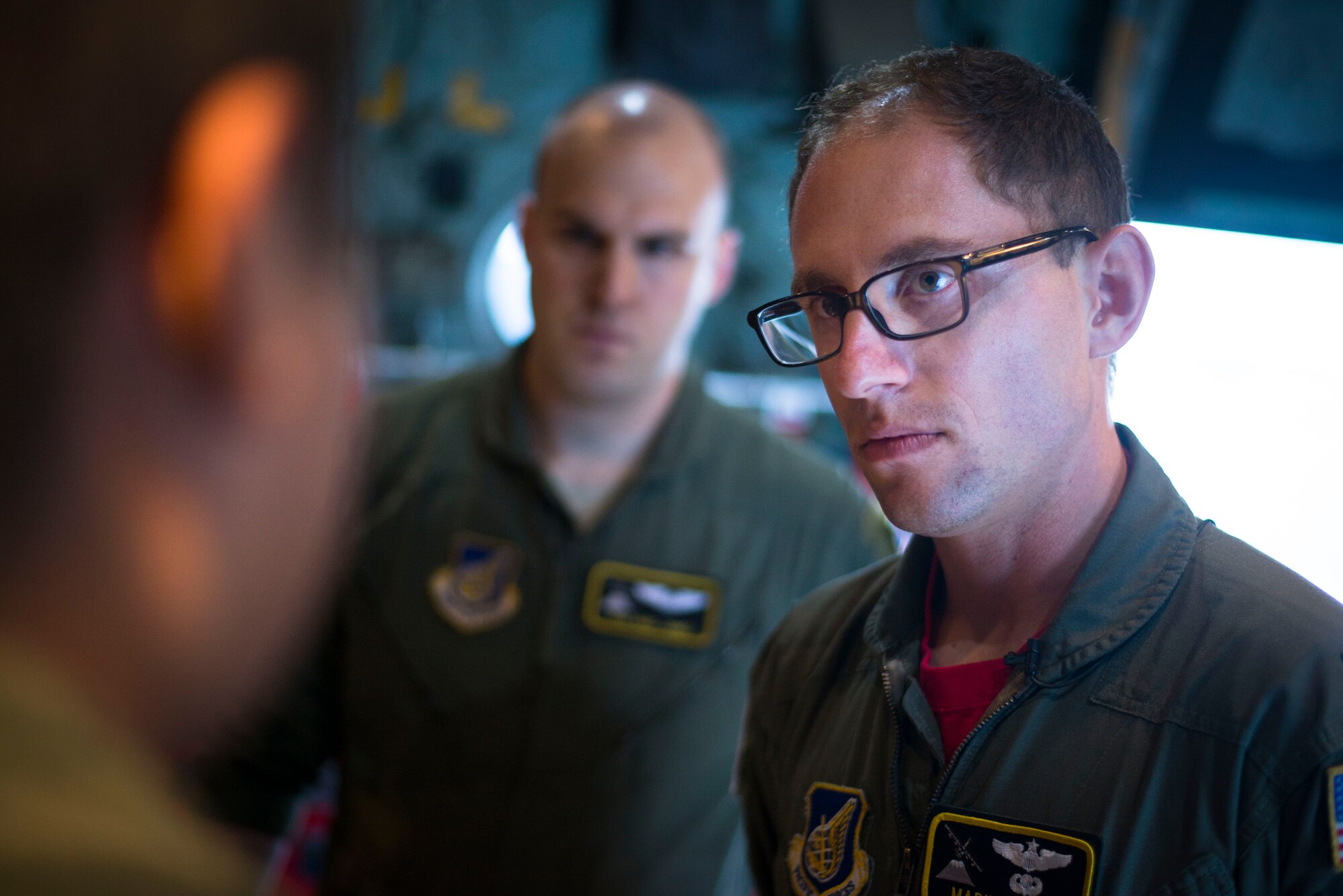 Capt. Mark Nexon, 36th Airlift Squadron pilot, listens to a loadmaster's brief before an off-site training sortie Aug. 2, 2014 at Joint Base Elmendorf-Richardson, Alaska. Aircrew from the 36 AS teamed up with Army paratroopers from the 25th Infantry Division to participate in realistic aerial combat training. (U.S. Air Force photo by Staff Sgt. Chad C. Strohmeyer/Released)