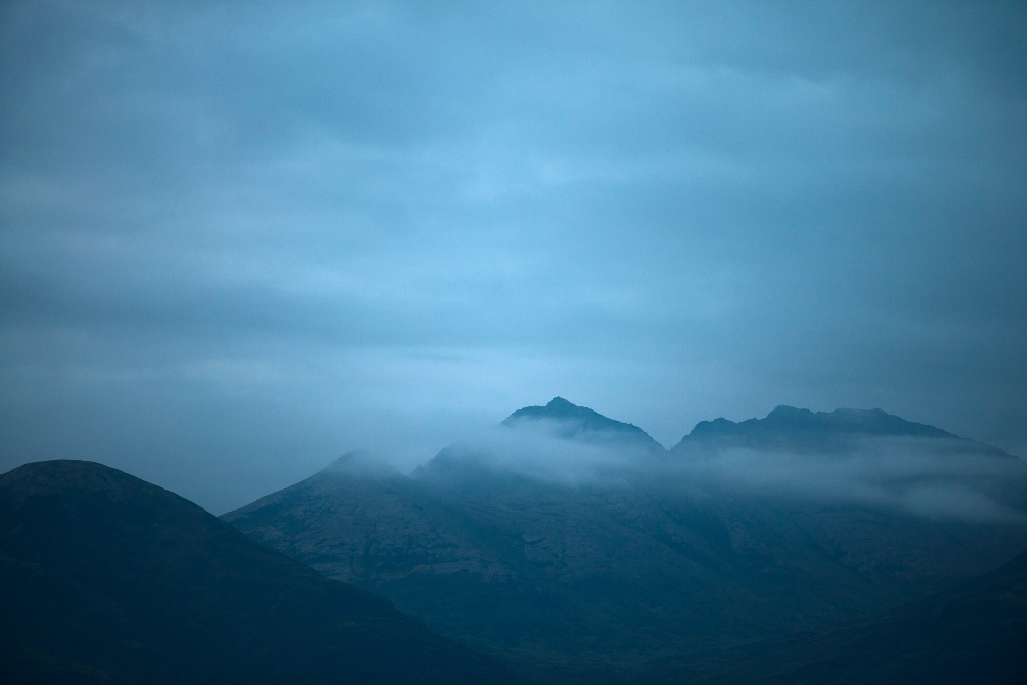 Clouds roll over a mountain range near Joint Base Elmendorf-Richardson, Alaska on Aug. 2, 2014. Mountain ranges such as these provided challenging training scenarios for pilots of the 36th Airlift Squadron. (U.S. Air Force photo by Staff Sgt. Chad C. Strohmeyer/Released)