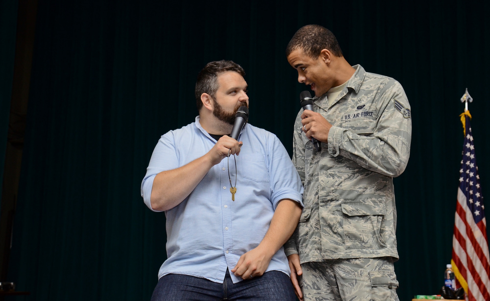 Senior Airman Michael Summers, 644th Combat Communications Squadron, tries to persuade Colin Sweeney, "A Shot of Reality With a Comedy Chaser" cast member, not to drink and drive after a party. Joint Region Marianas sponsored the comedy show designed to educate Airmen and Sailors on the dangers and responsibilities that come with drinking alcohol. (U.S. Air Force photo by Staff Sgt. Robert Hicks/Released)